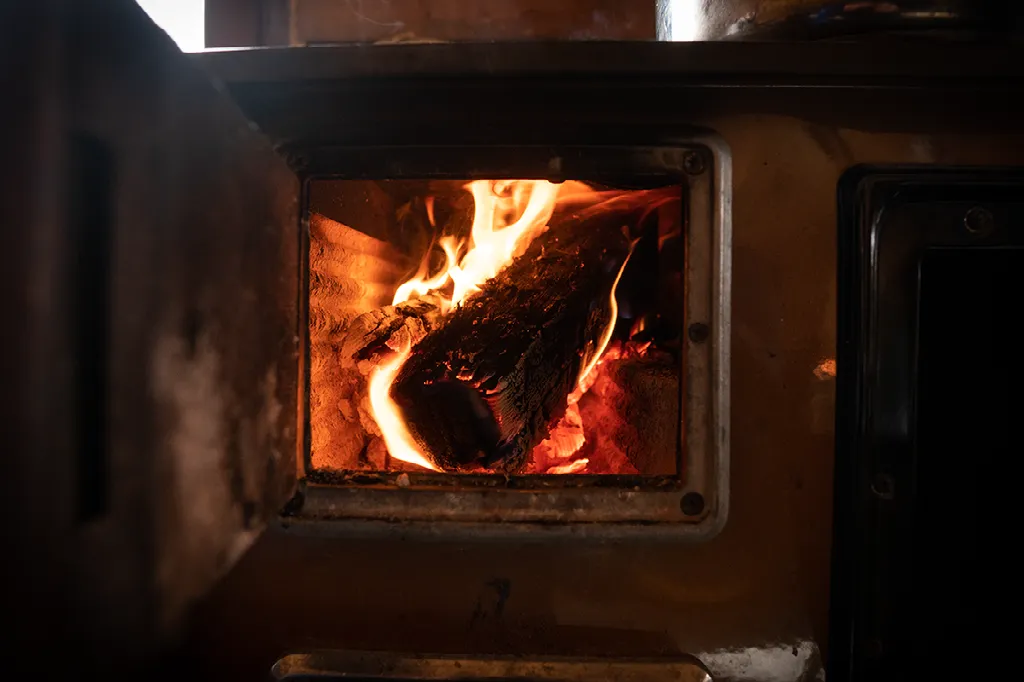 Close-up van brandend hout in de vuurhaard van een rustieke houtkachel.