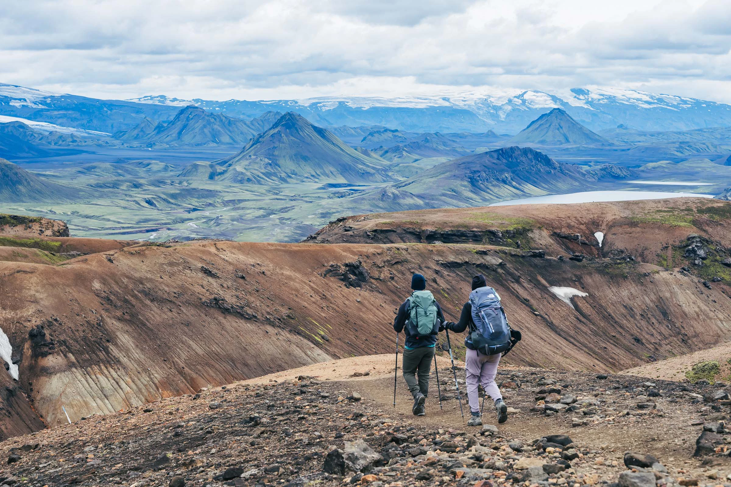 Twee wandelaars lopen door kleurrijke heuvels