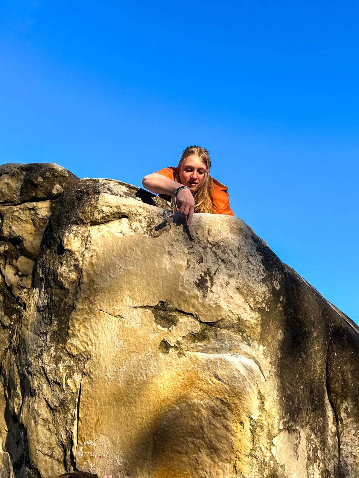 Klimmer die in een lage grot ligt met een crashpad