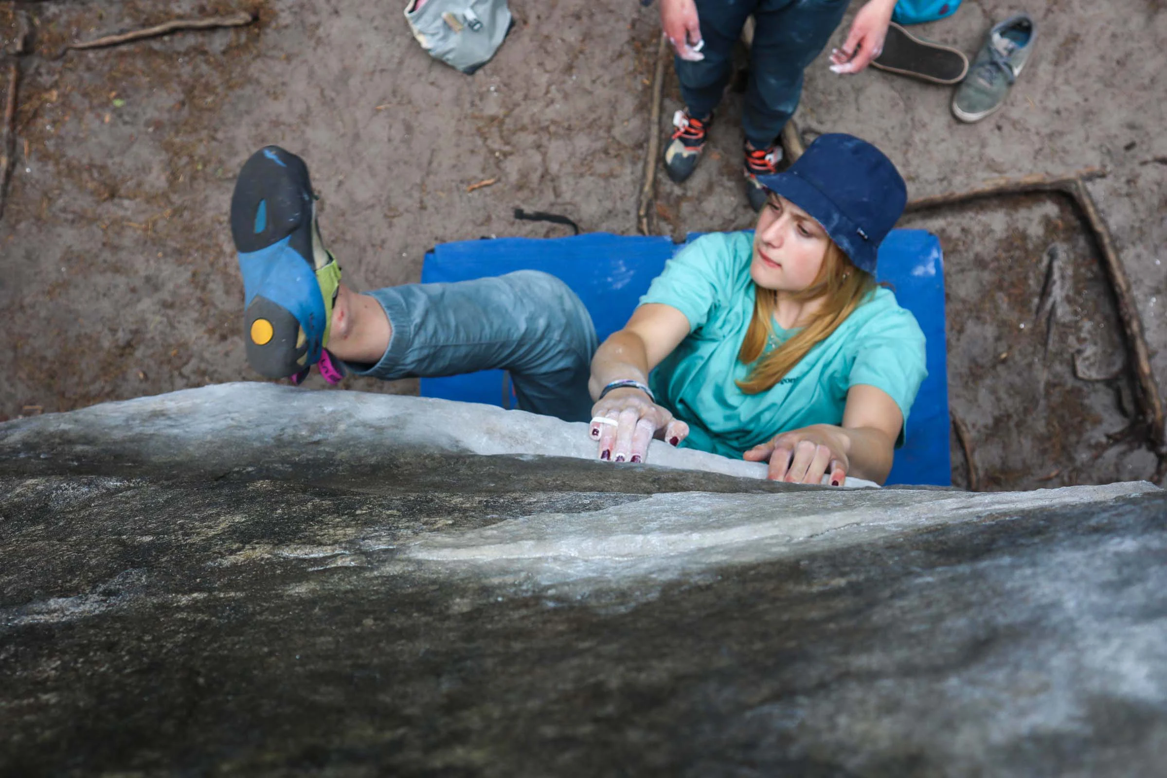 Klimmer die rust op een crashpad onder een rots