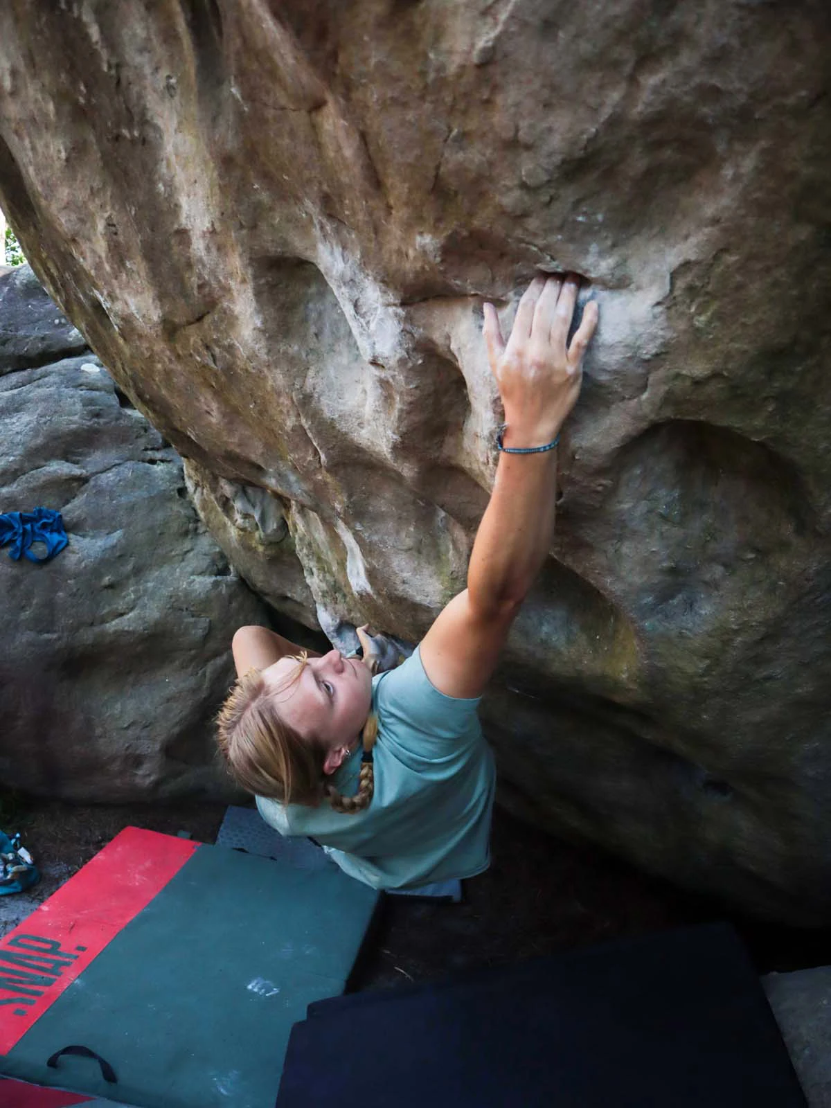 Klimmer die naar een greep reikt onder een overhang