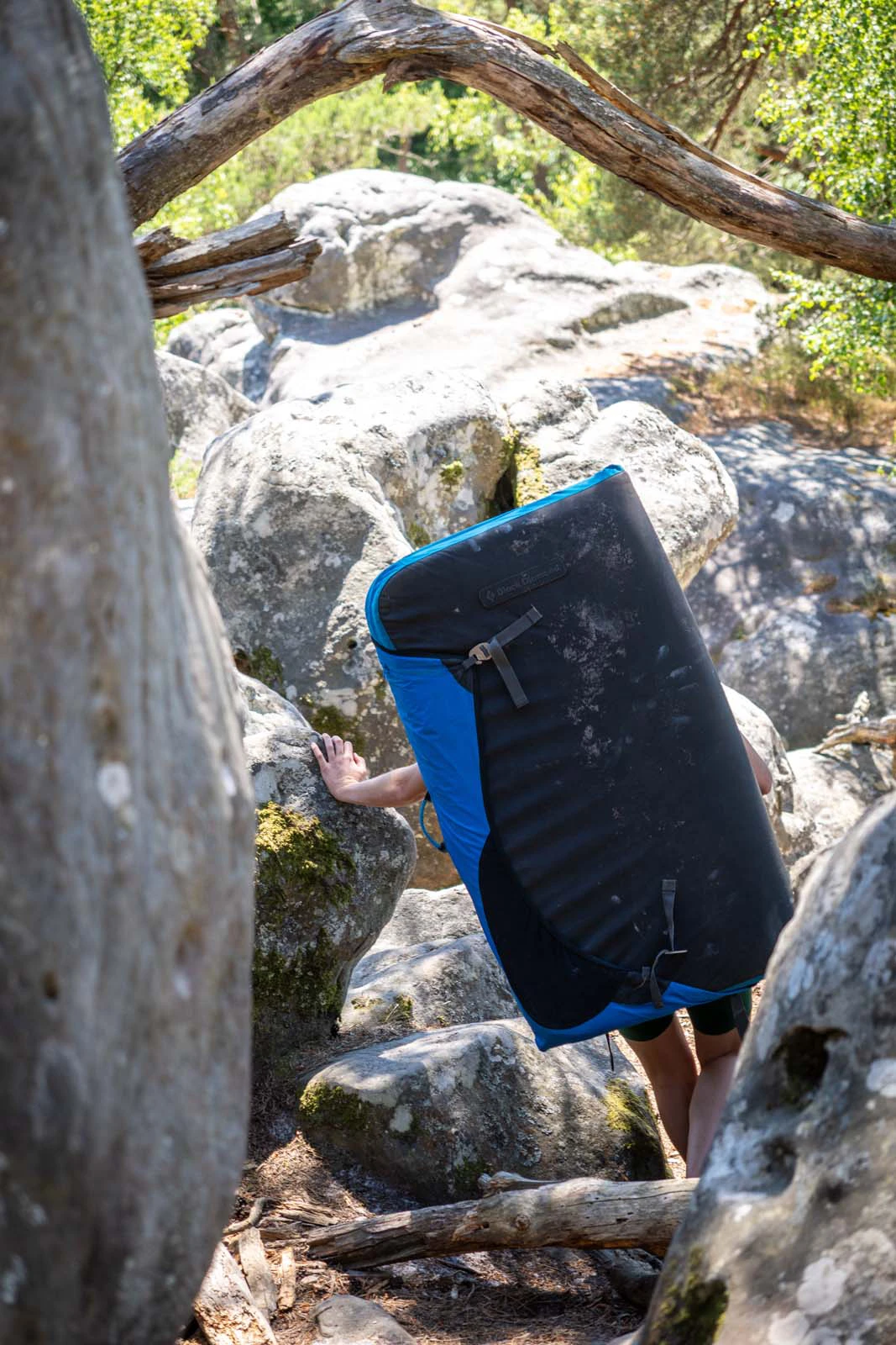 Klimmer die een crashpad draagt door het bos