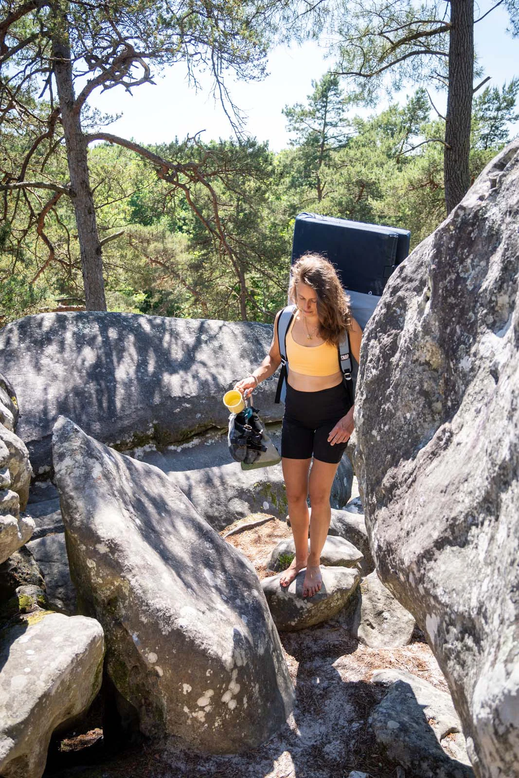 Klimster bij een boulder met crashpad