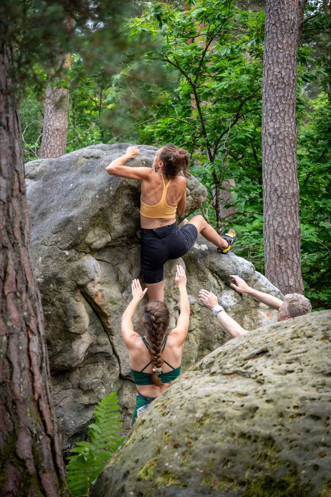 Klimmer die zich opduwt langs een brede boulder
