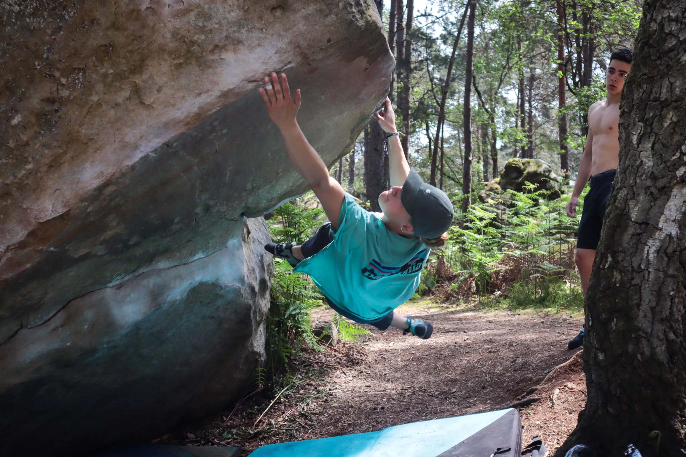 Klimmer reikt naar een greep op een rots