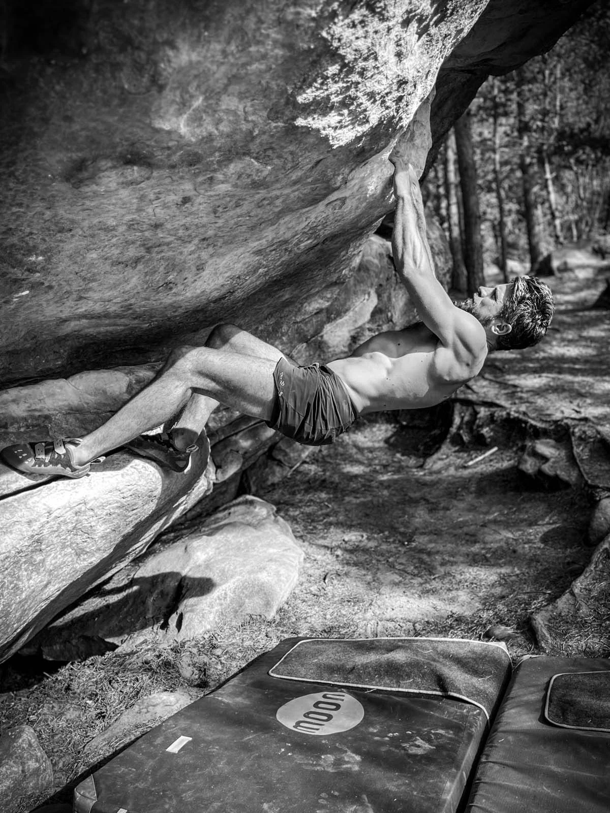 Klimmer onder een overhangende rots in zwart wit