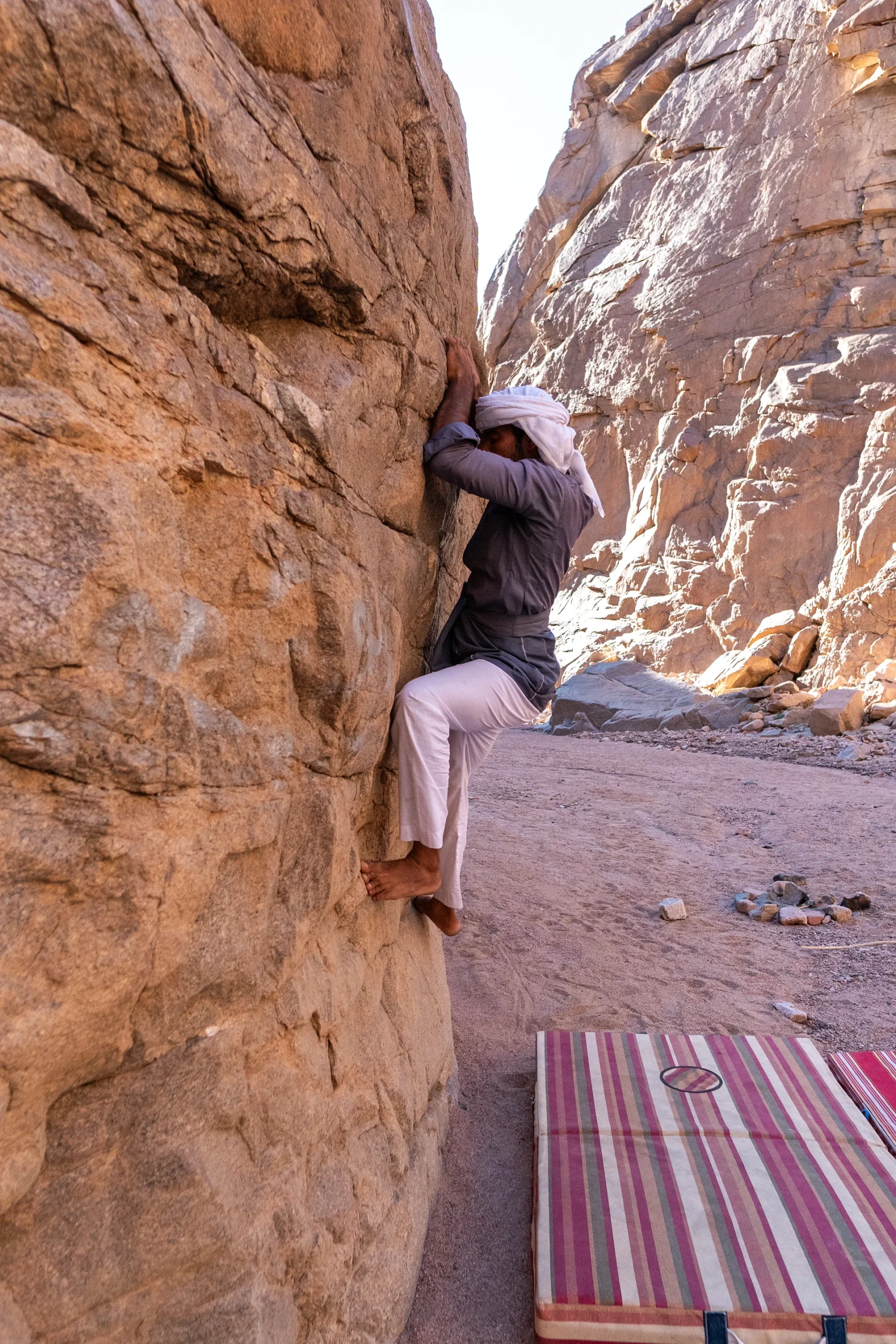 Klimmer in smalle kloof tussen zandsteenwanden