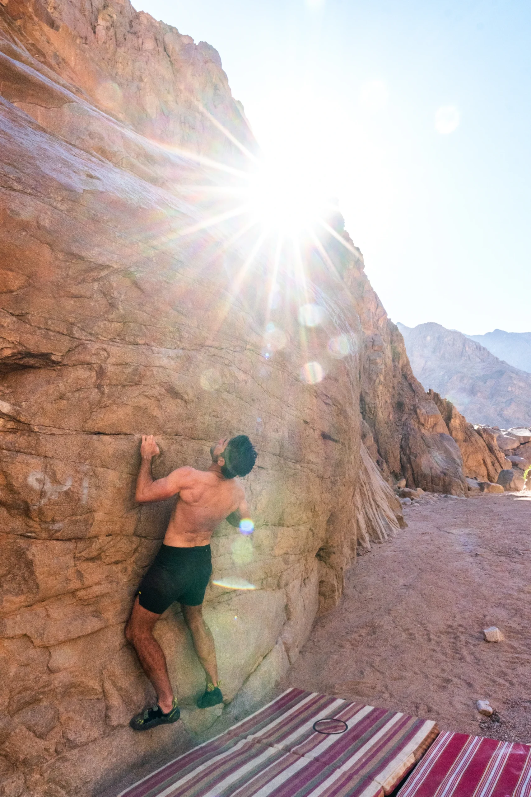Klimmer in tegenlicht op een steile rots