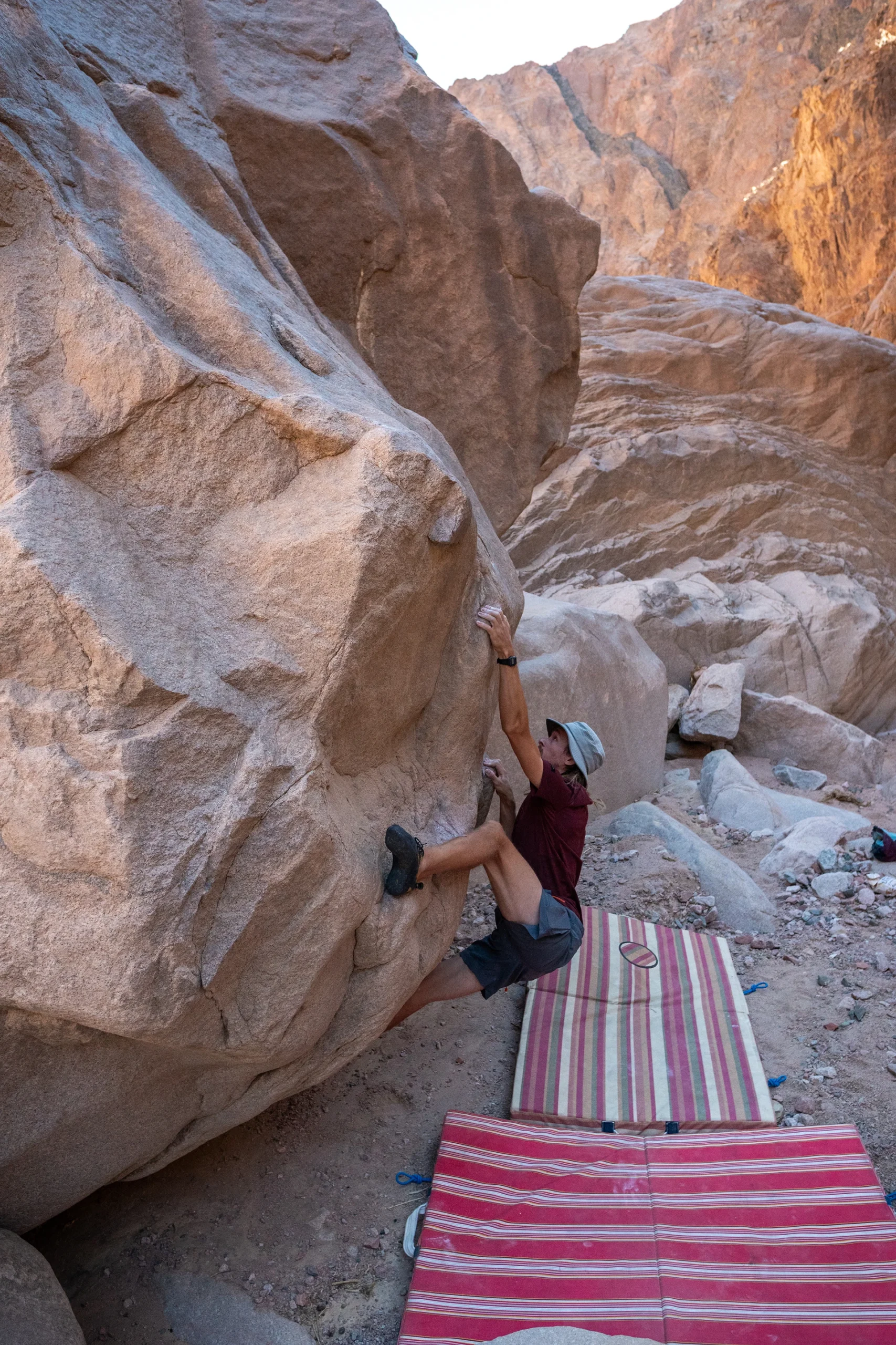 Klimmer werkt aan een boulderprobleem tussen hoge wanden