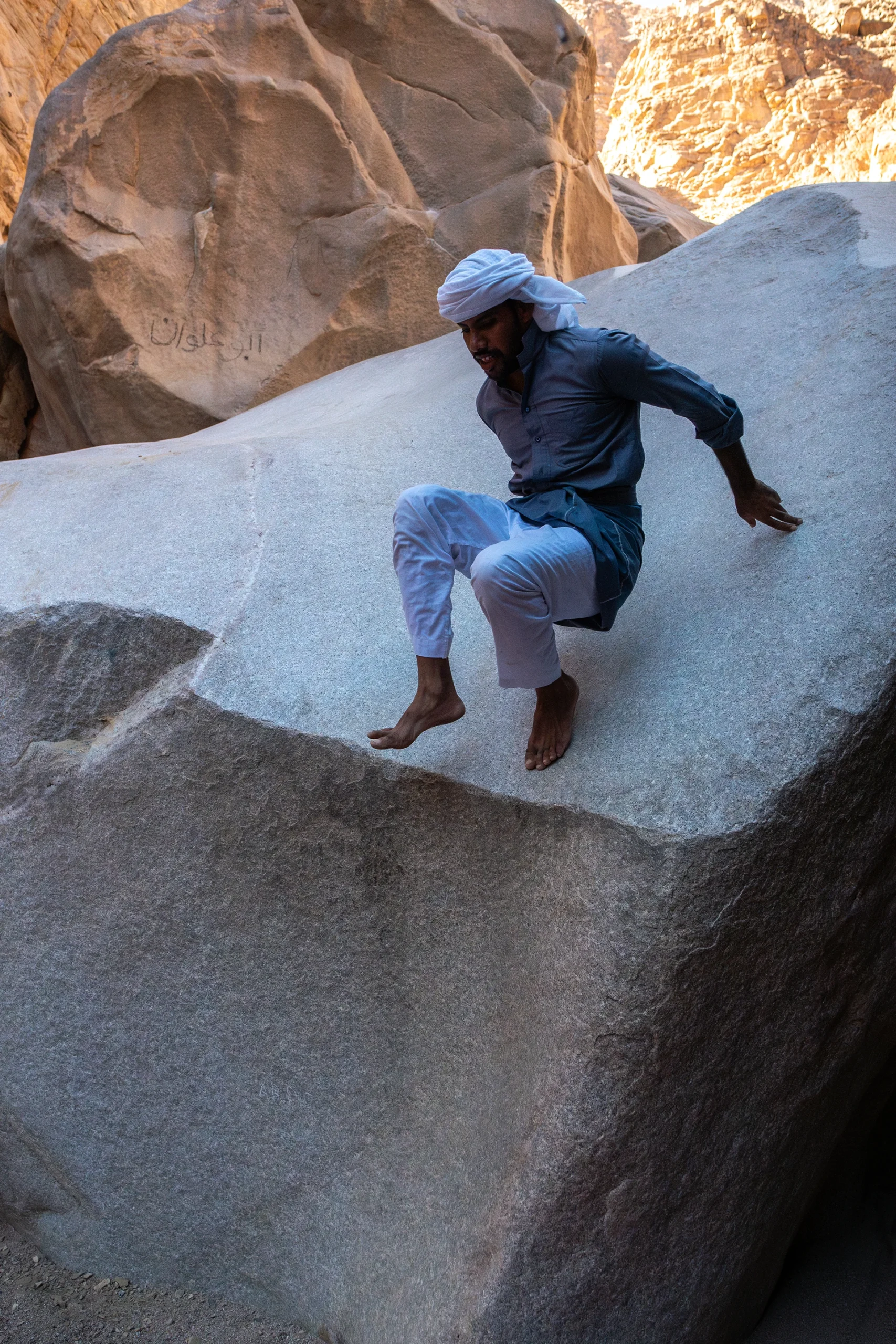 Klimmer zit op een ronde rotsplaat