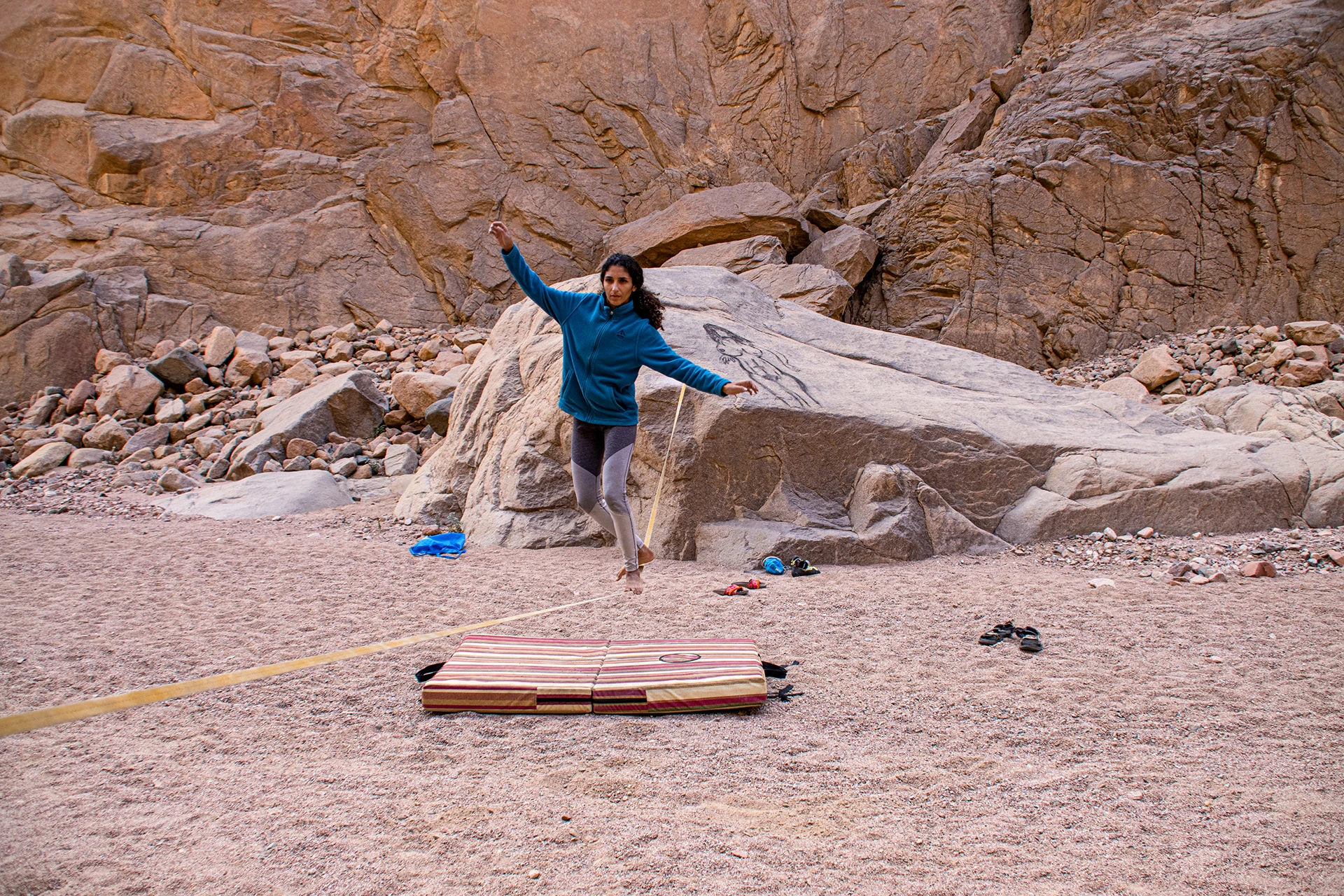 vrouw balanceert op touw voor rotsen