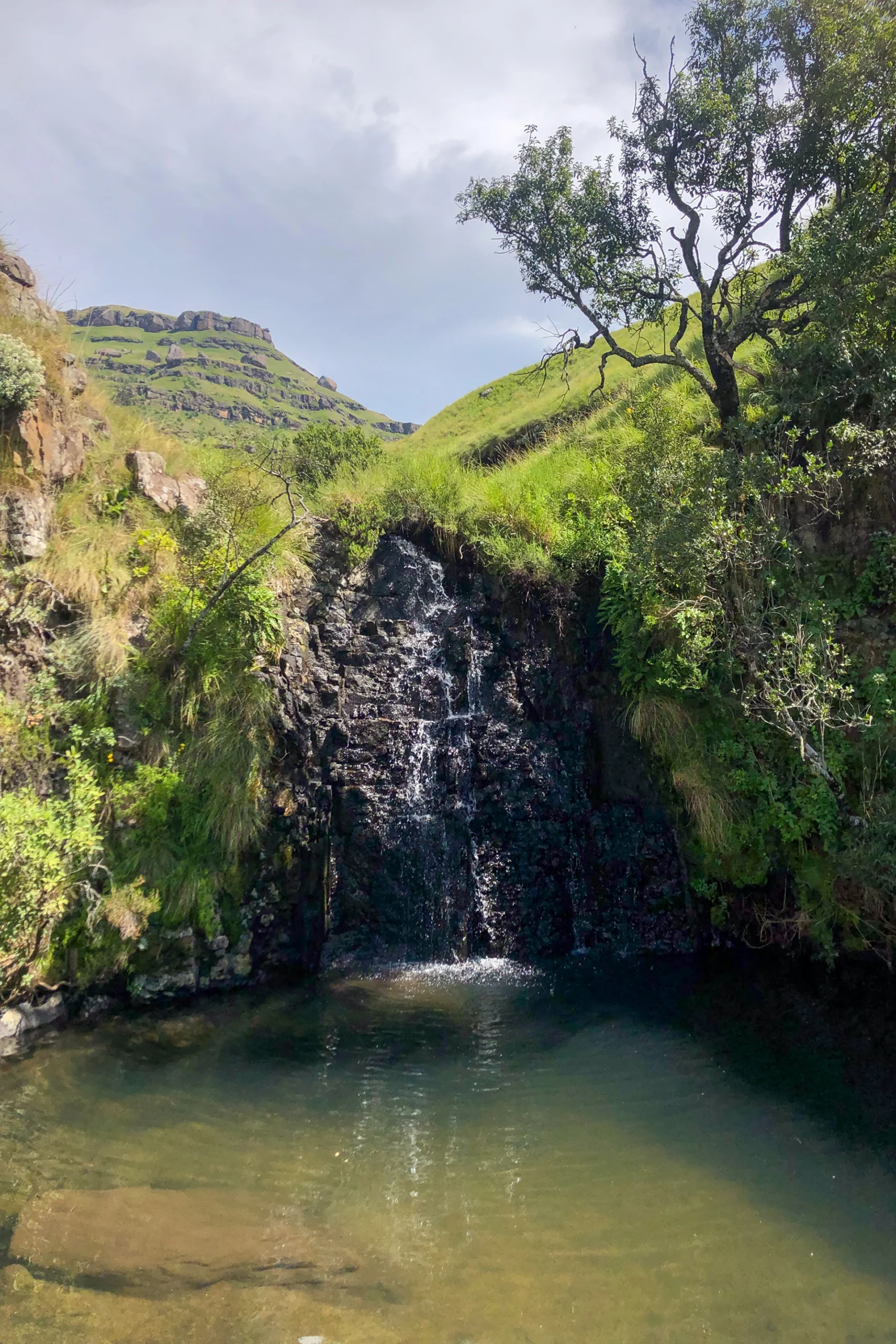 Kleine waterval tussen groene rotsen