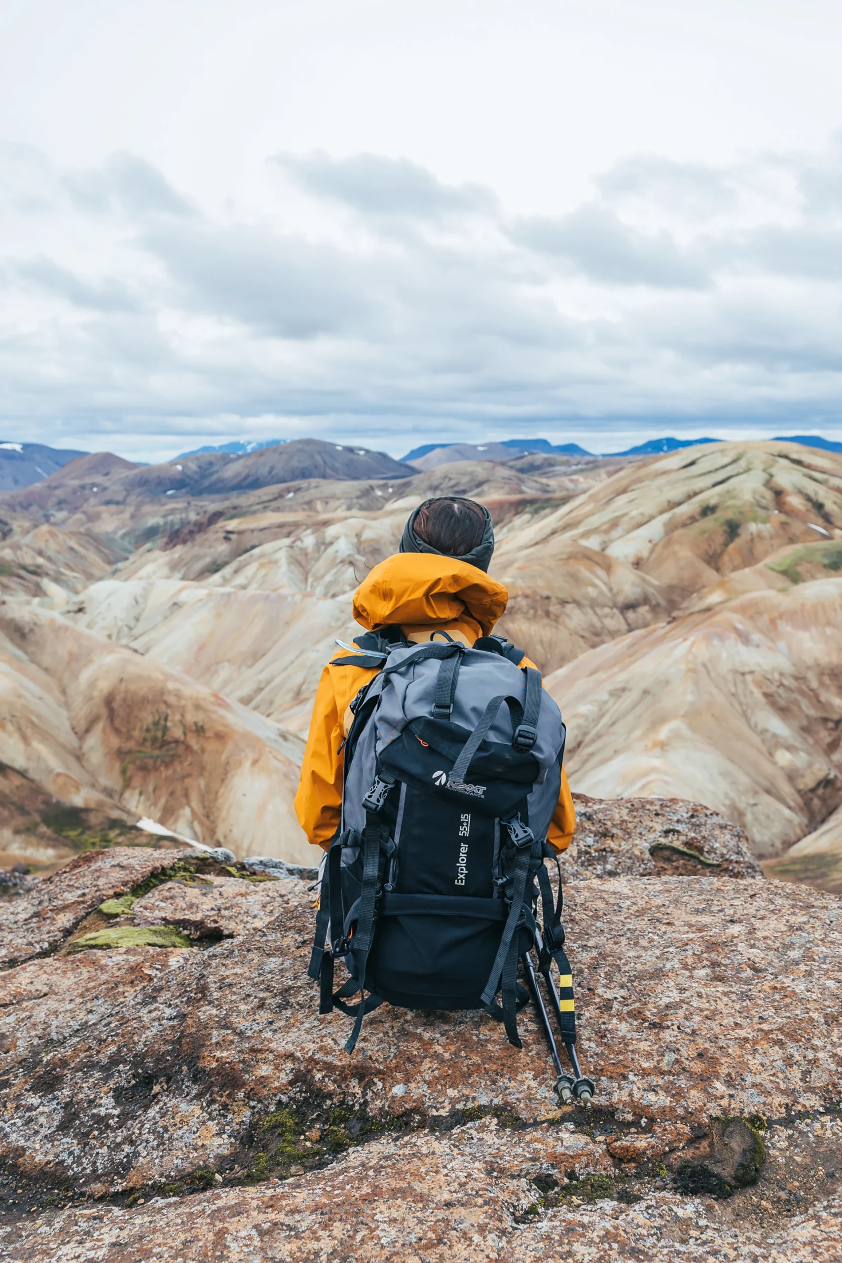 Wandelaar kijkt uit over kleurrijke rhyolietbergen