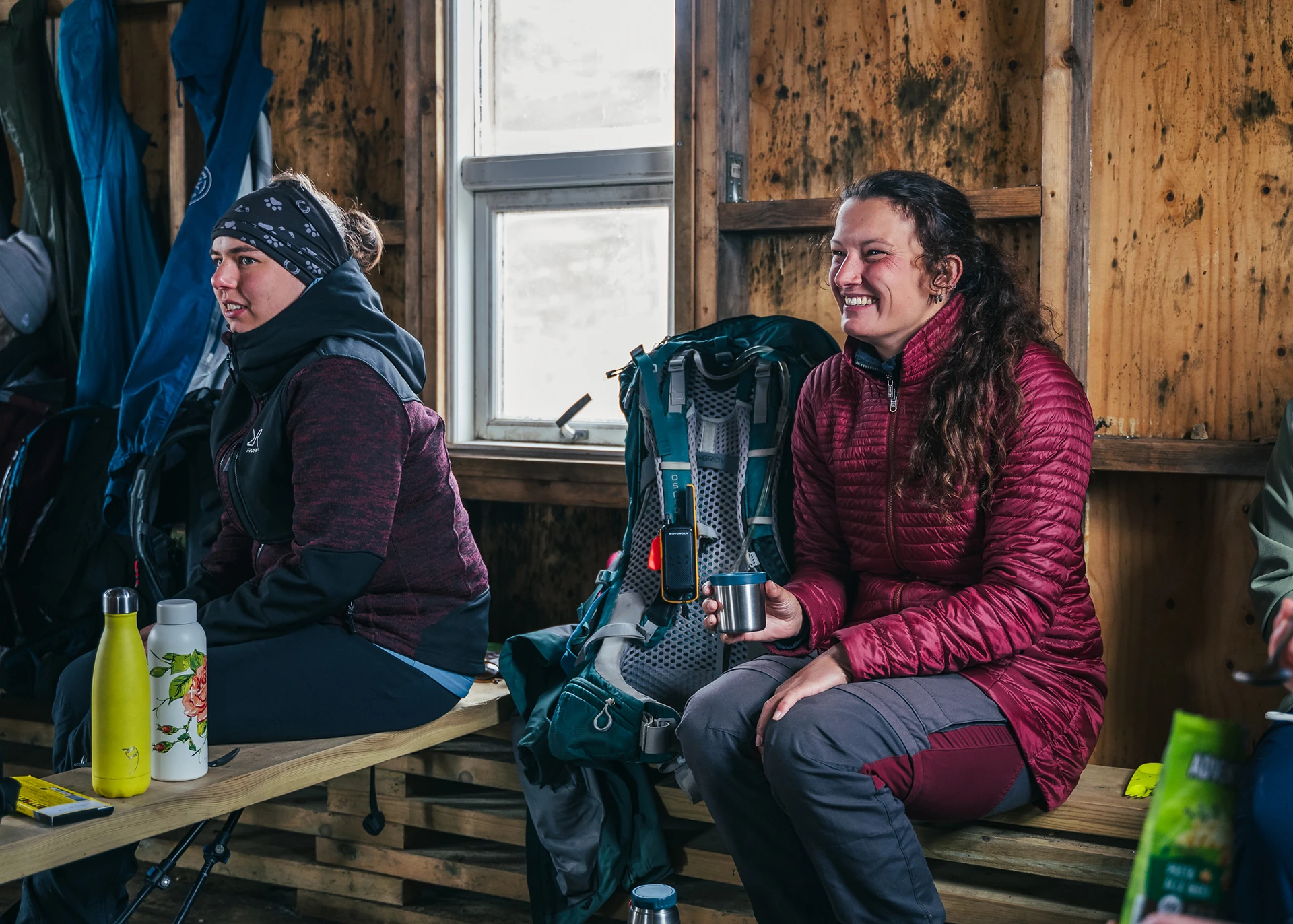 Mensen zitten in berghut met rugzakken