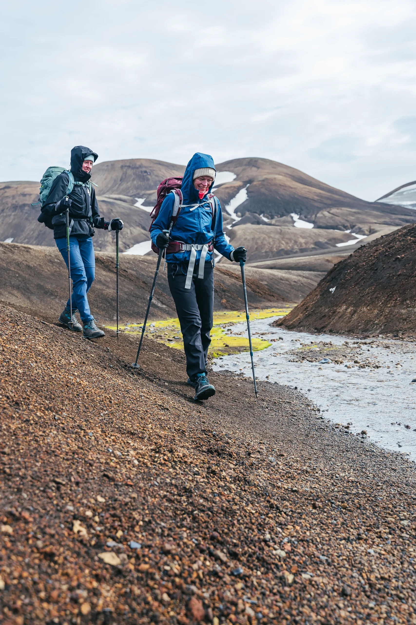 Twee wandelaars lopen door heuvelachtig terrein