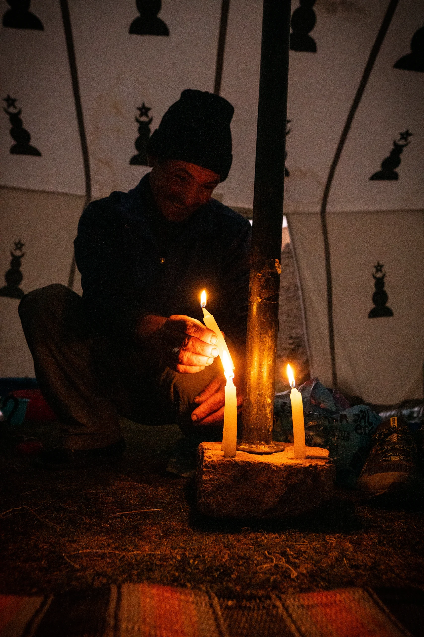 Man maakt licht met kaarsen in een tent