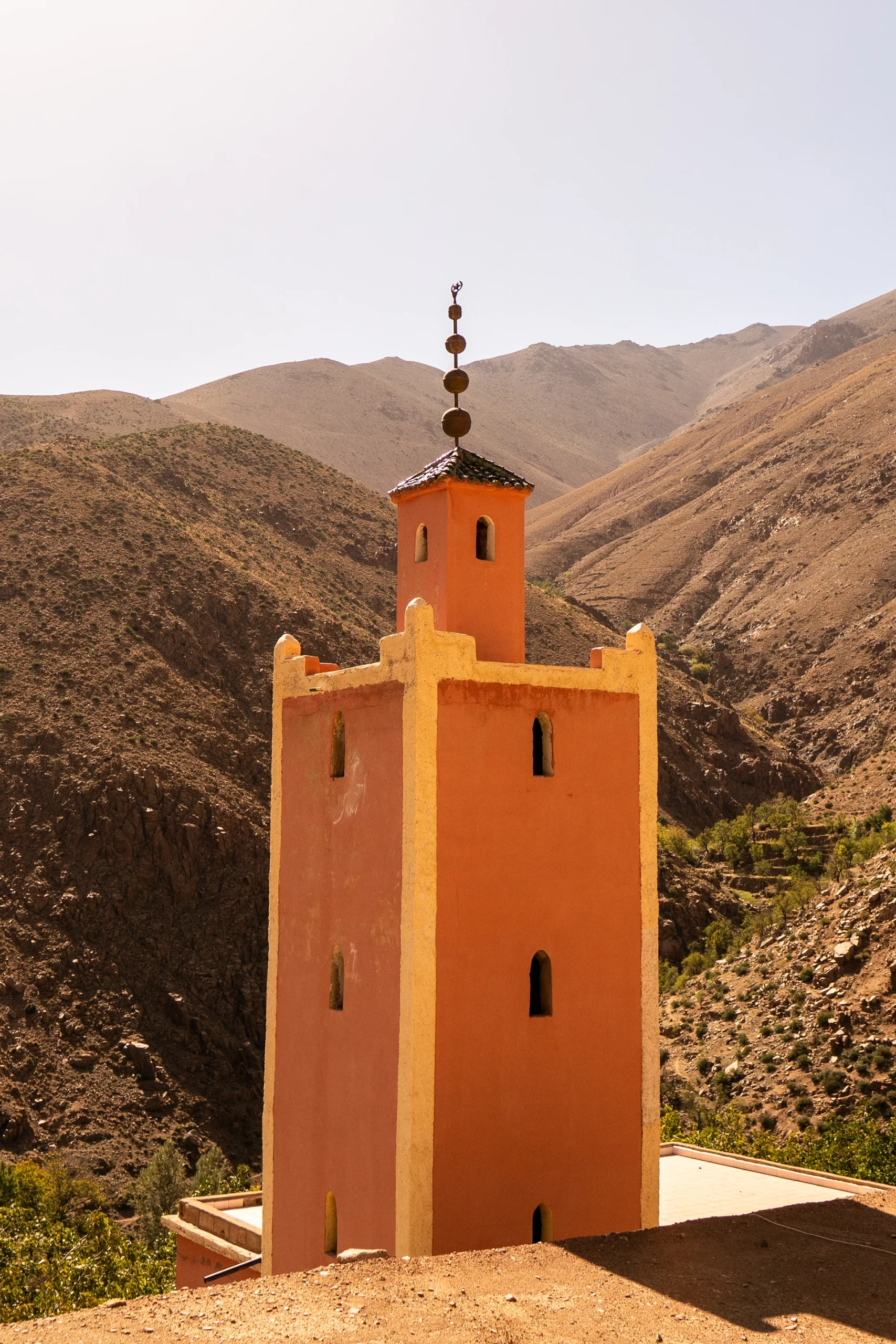 Oranje minaret tussen berghellingen