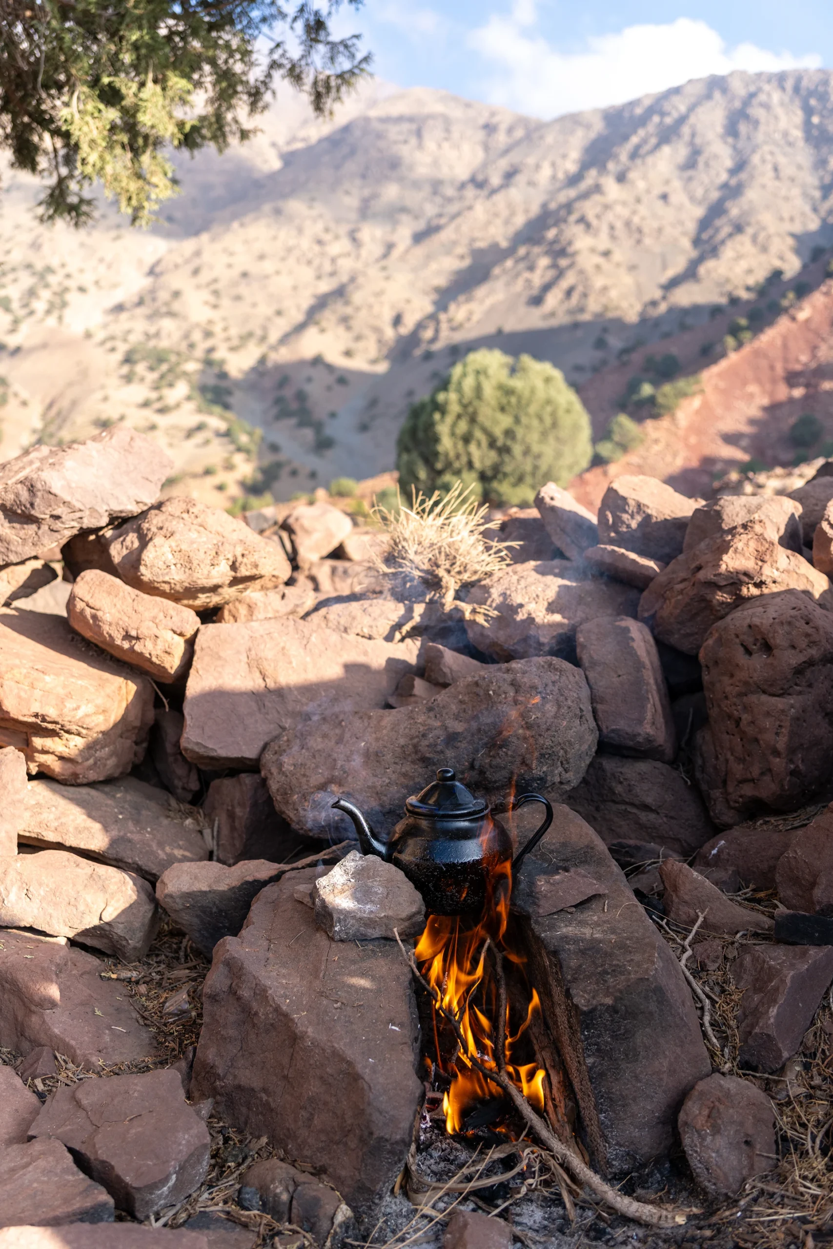 Theepot en glazen op rotsen met uitzicht