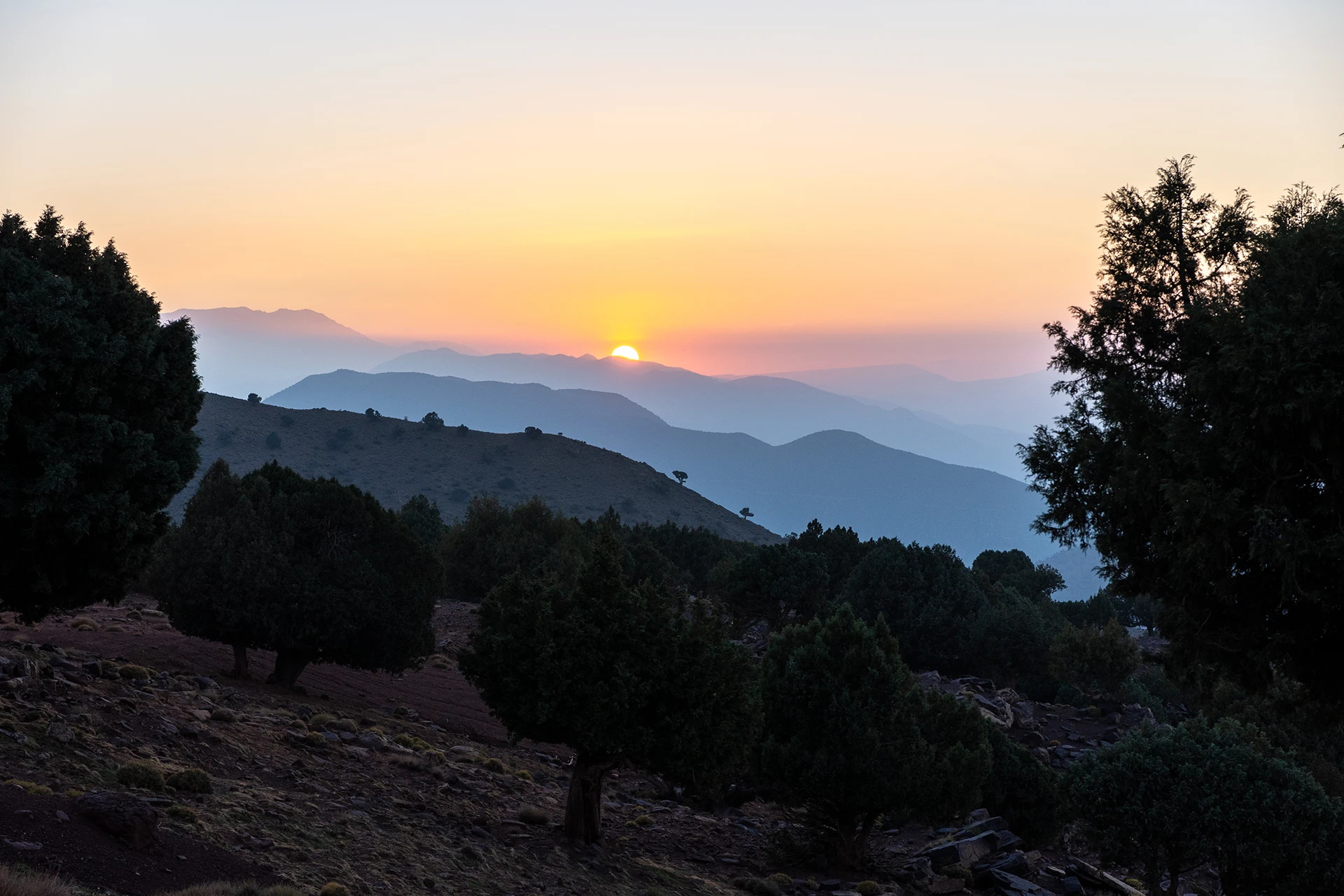 Zonsondergang achter lagen van heuvels