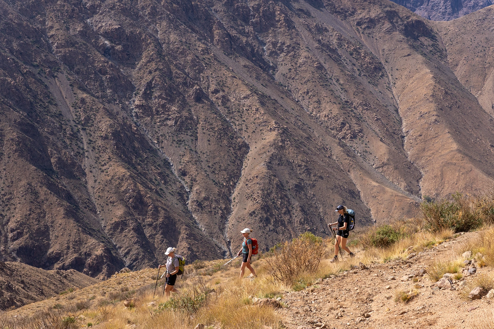 Wandelaars lopen langs een droge rotswand