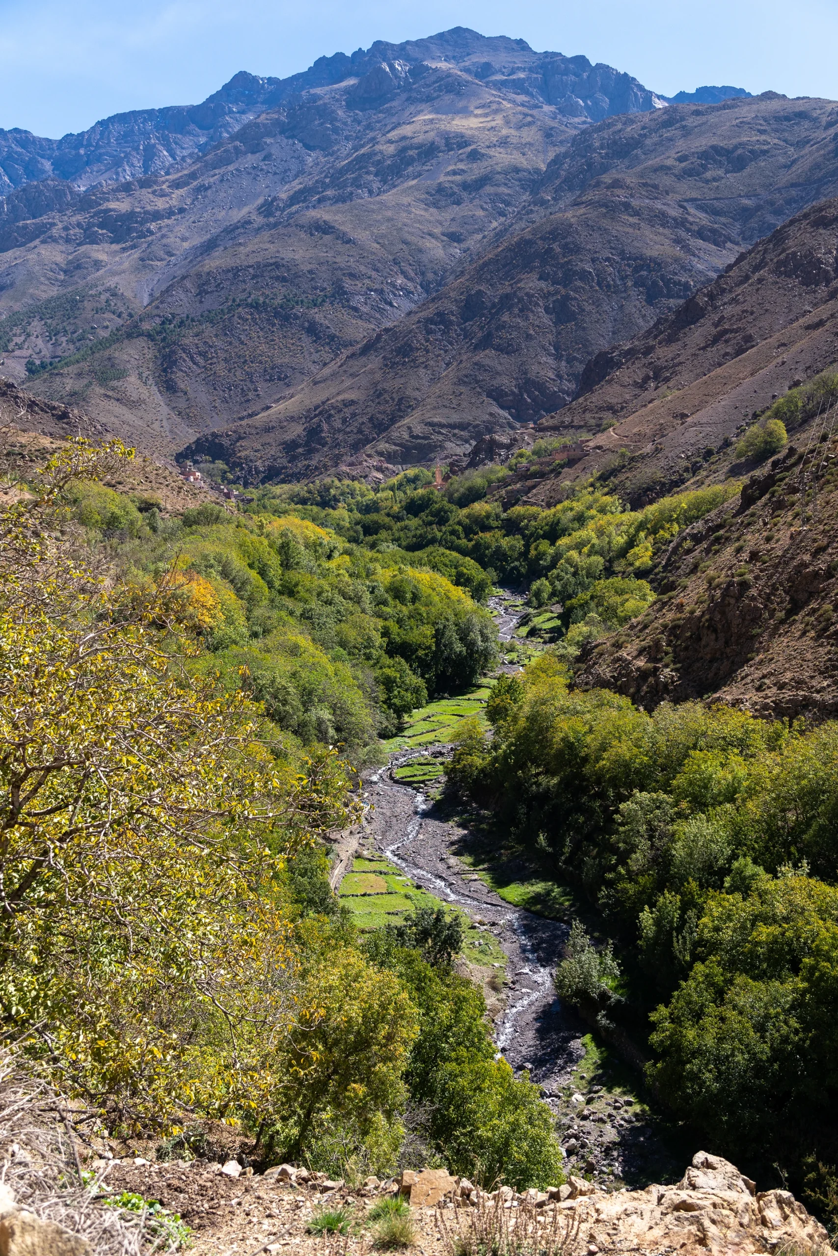Groene rivierkloof tussen droge berghellingen
