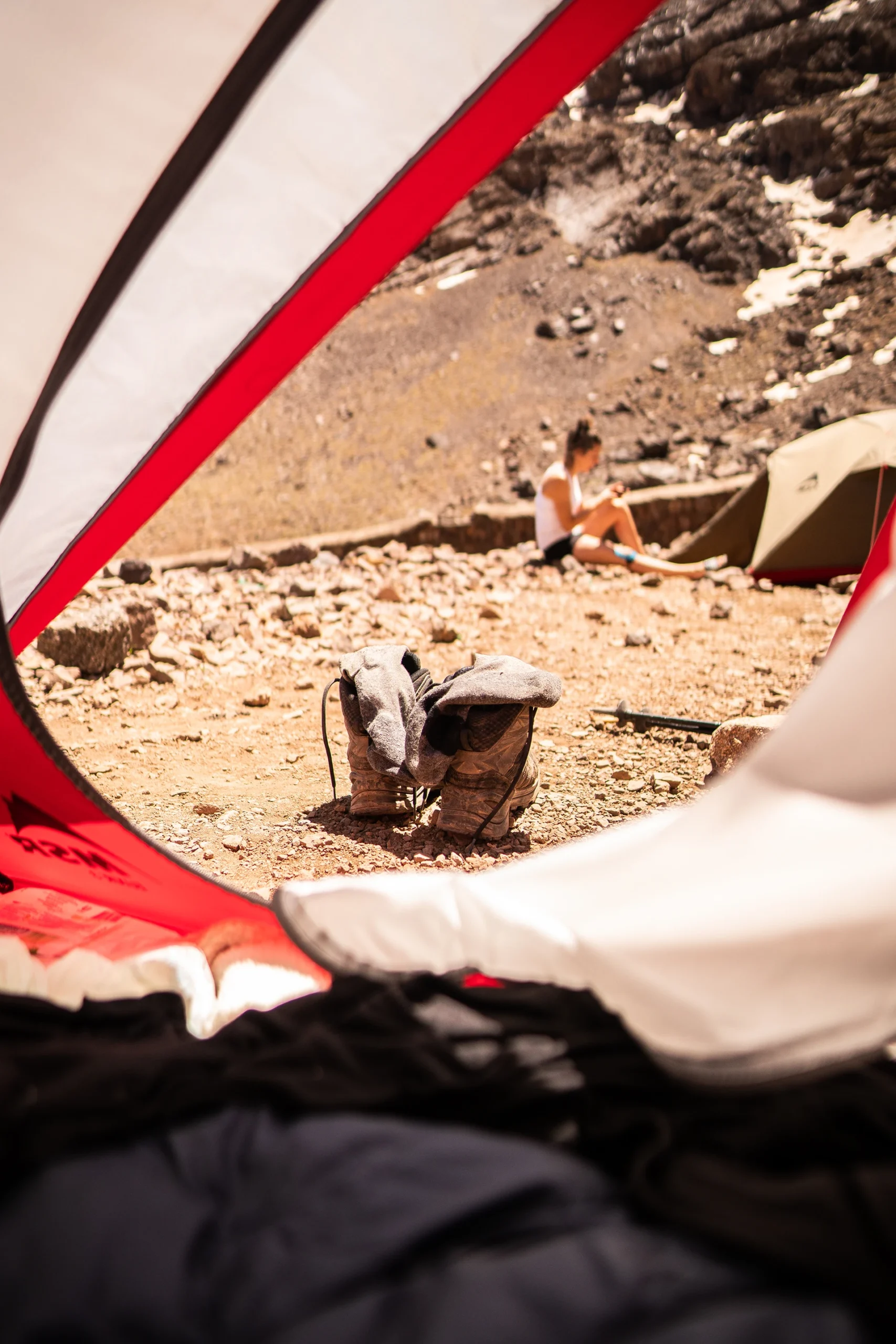 Kampeerplek met tent en rugzak in rotsig landschap