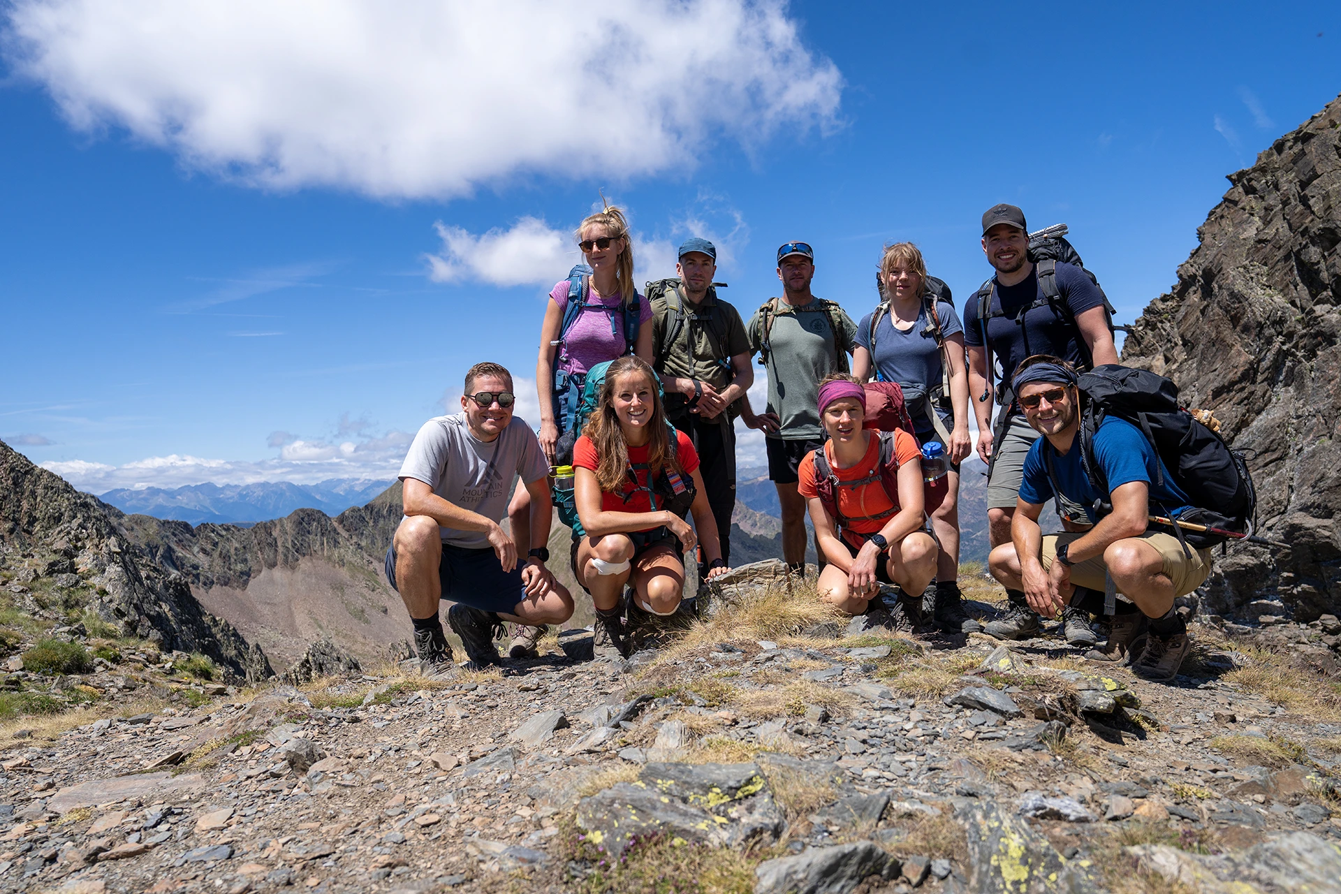 Groep hikers poseert op een rotsige bergtop