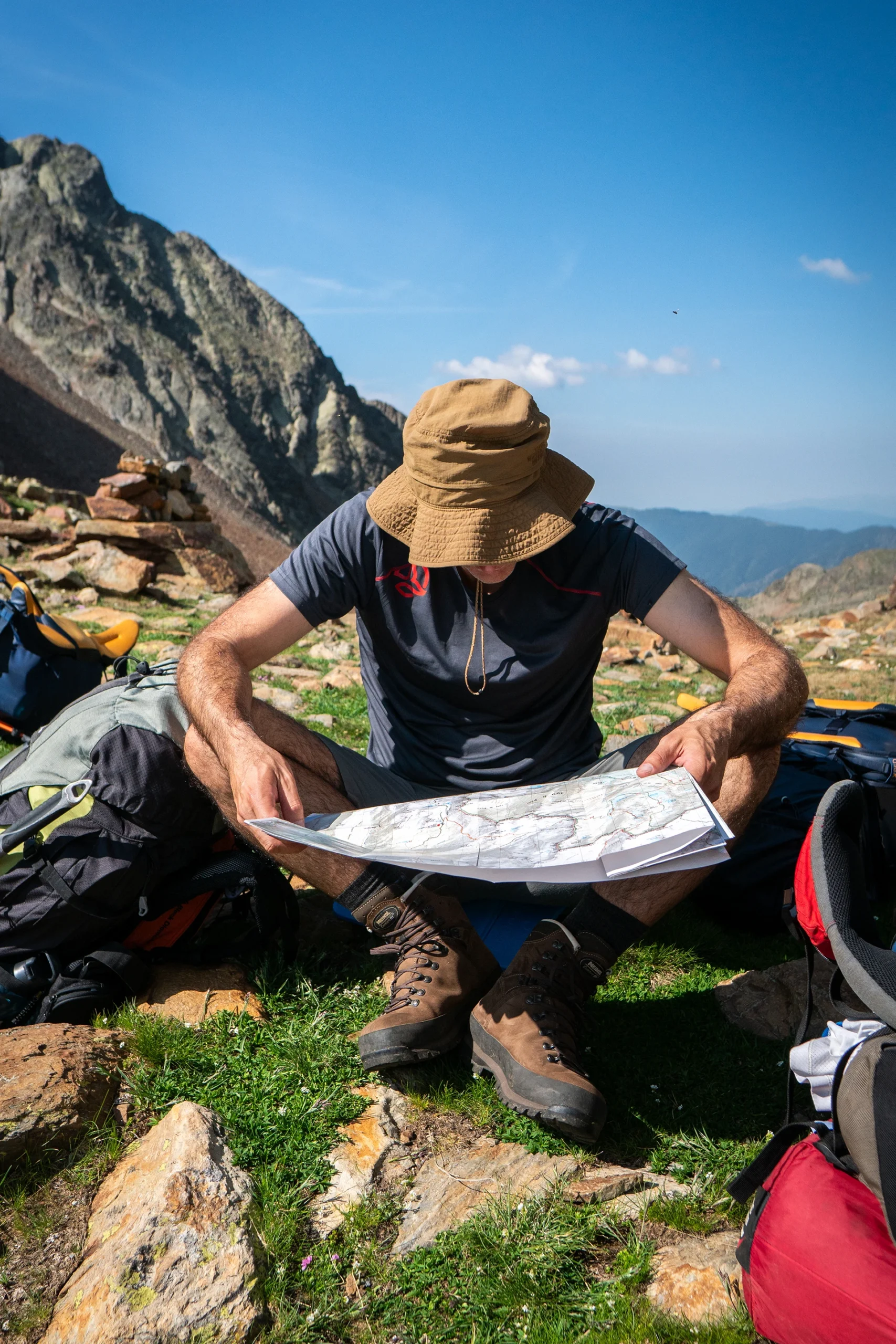 Hiker leest kaart zittend op rots