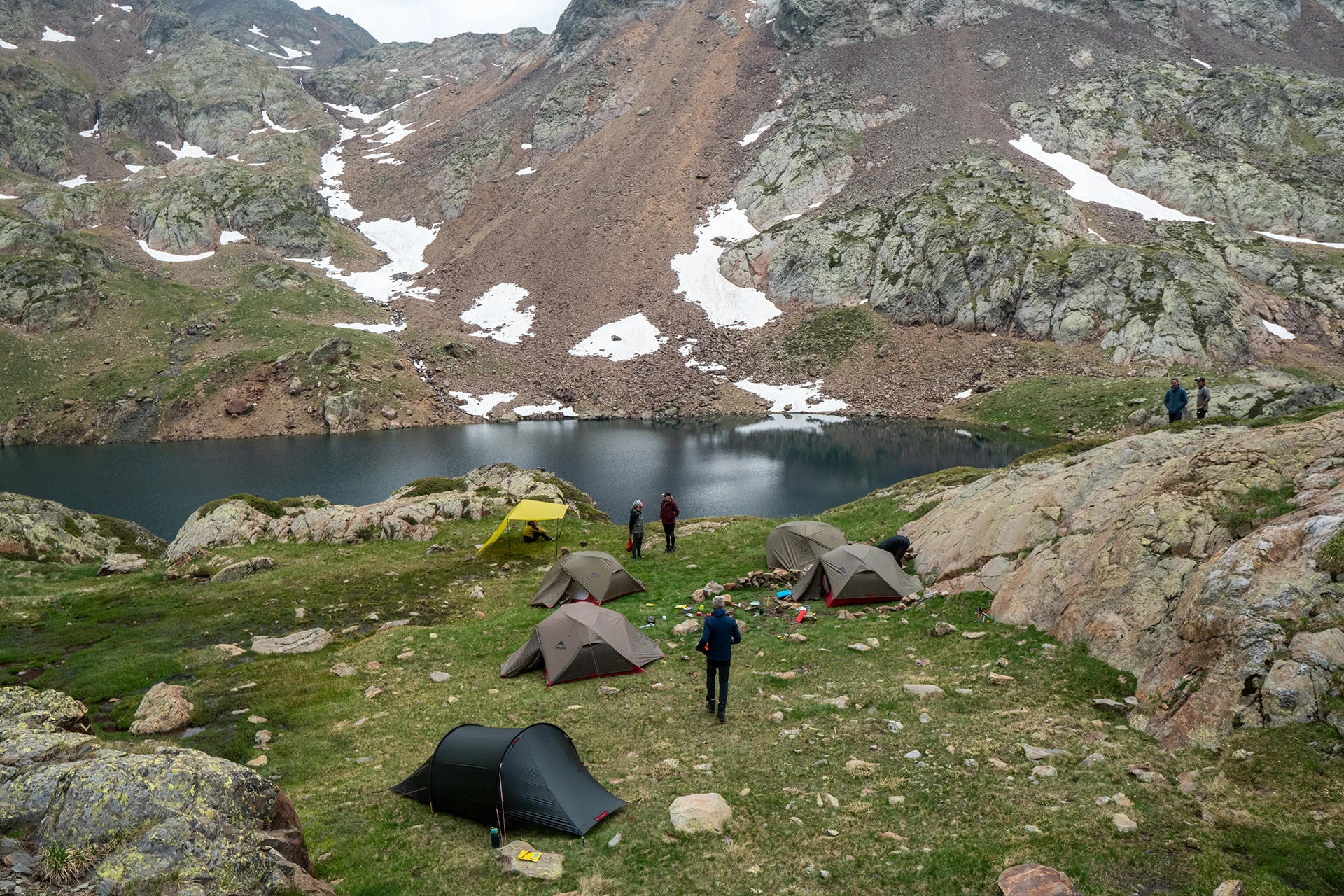 Tentenkamp in groen dal tussen rotsen