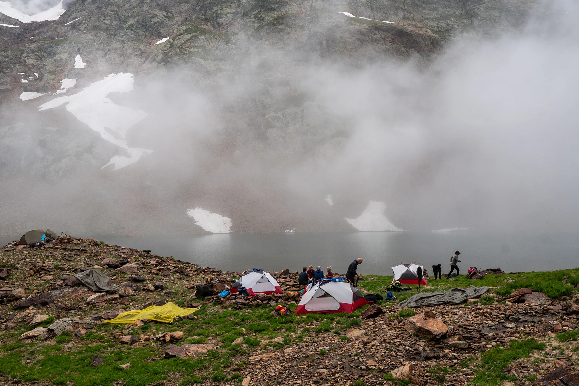 Wolk hangt laag boven tentenkamp in rotsachtig gebied