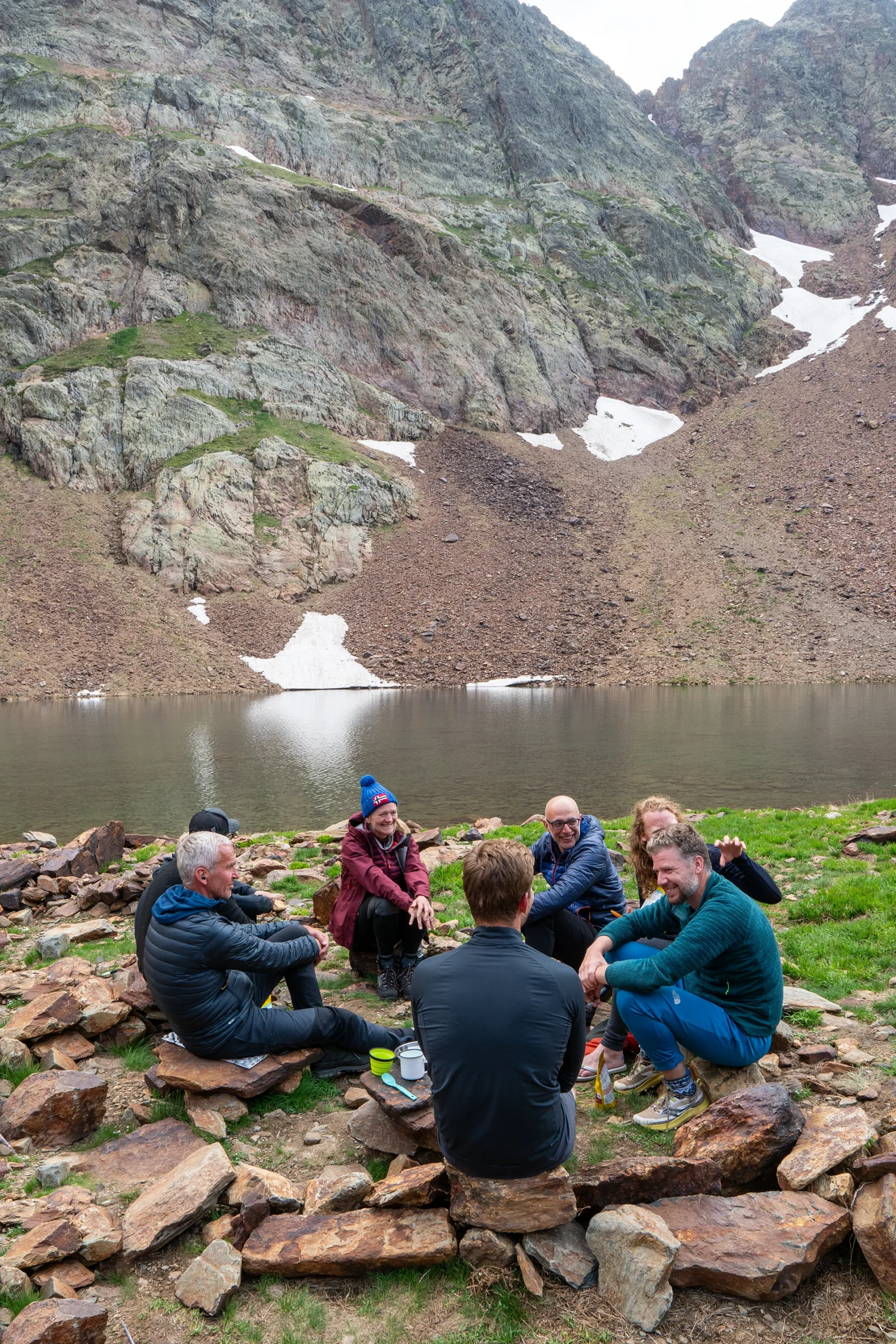 Groep zit bij bergmeer met steile wanden