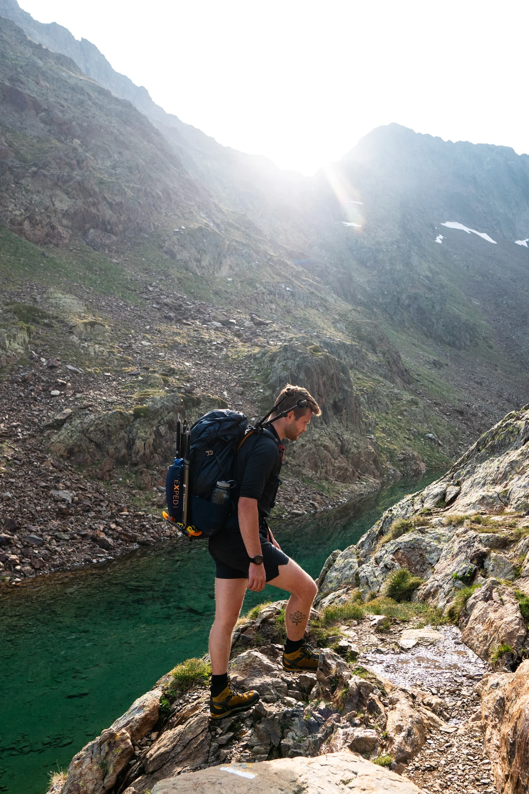 Wandelaar loopt langs groenblauw bergmeer