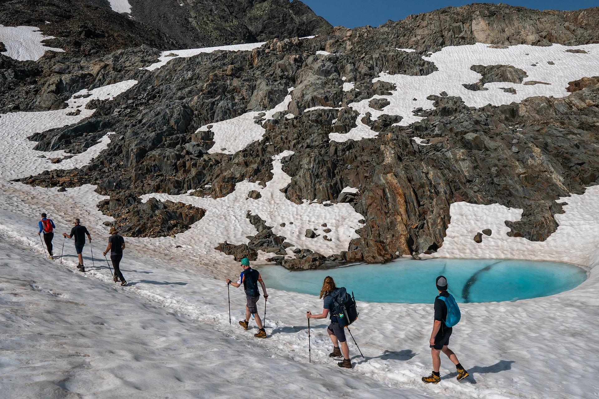 Hikers steken sneeuwveld over in de bergen