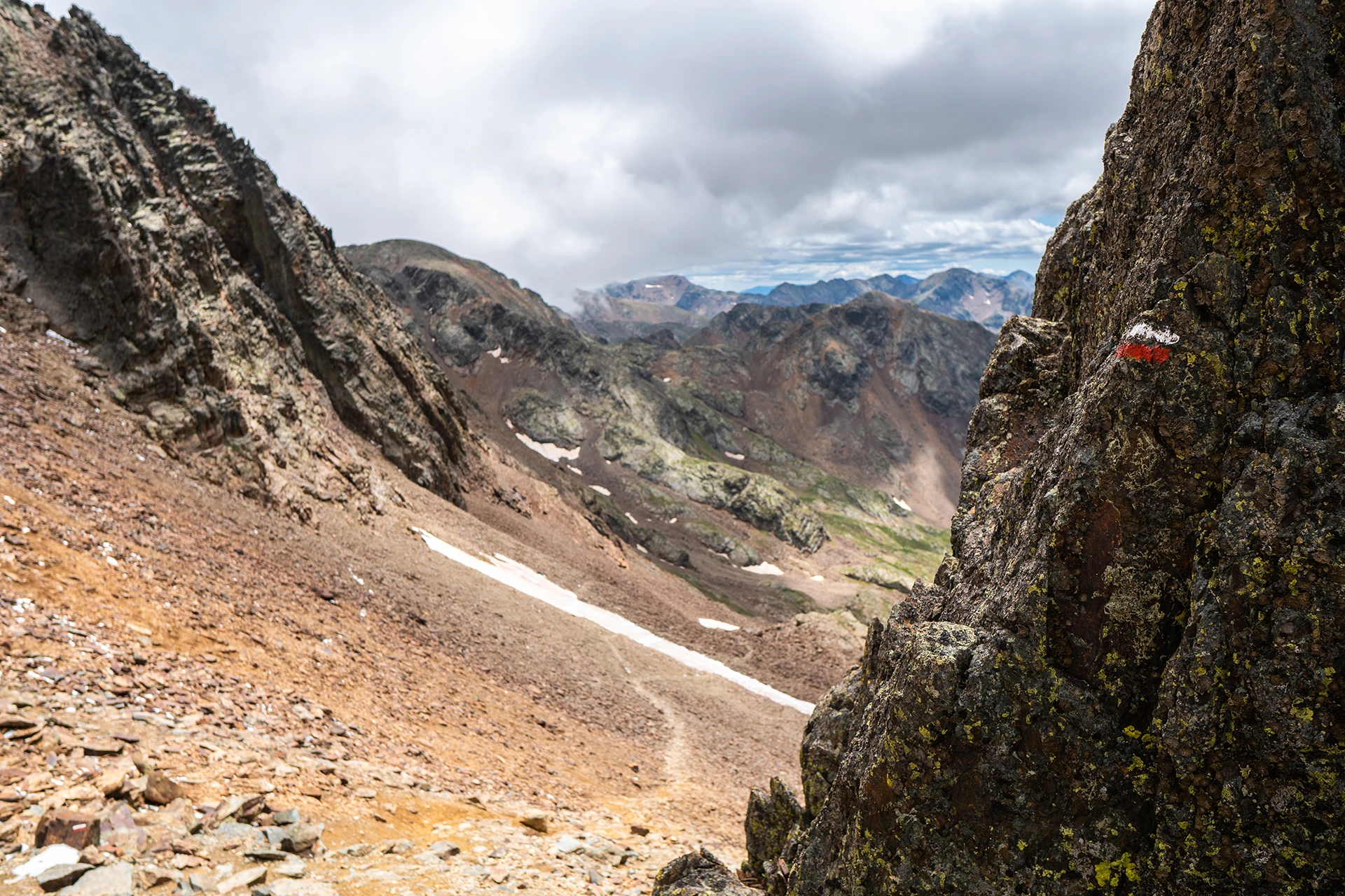 Rotsige bergpas onder wolkenlucht
