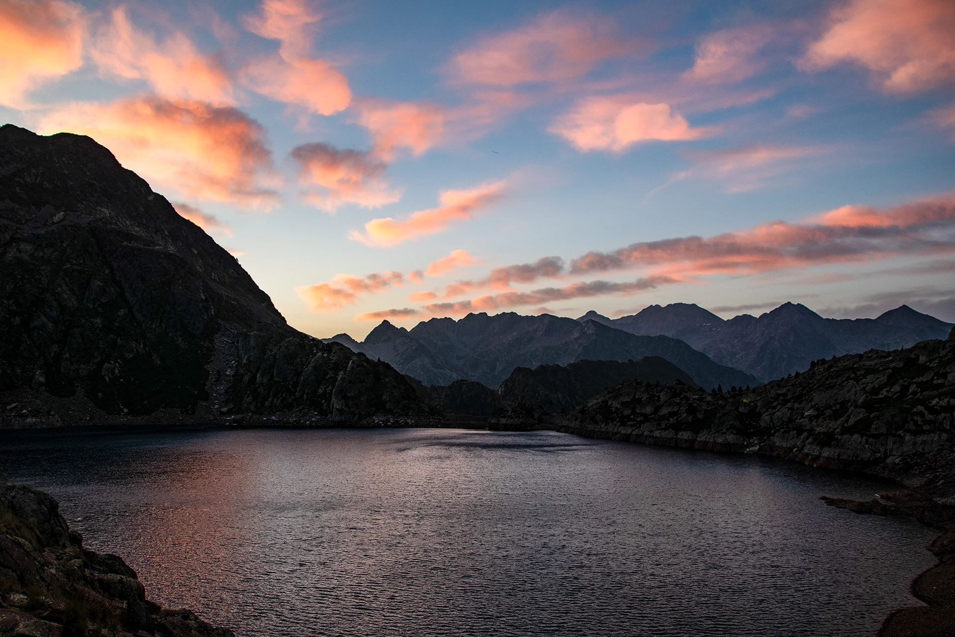 Bergmeer onder roze avondlucht