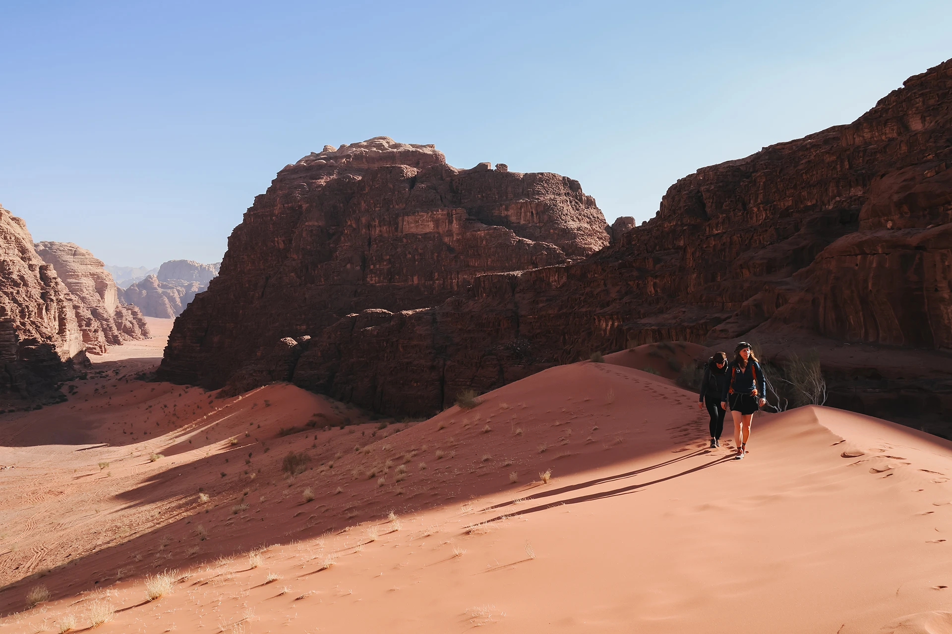 Roodbruine rotswanden boven zandige vlakte