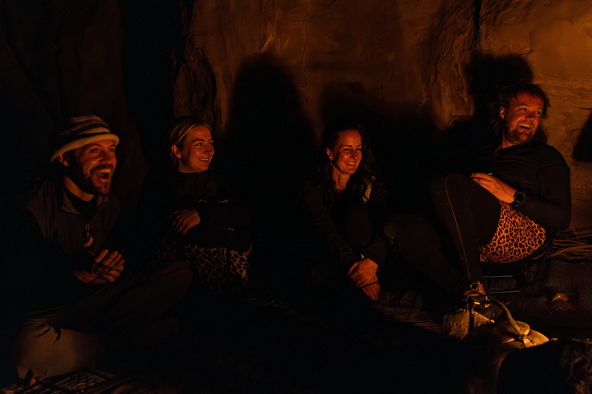 Mensen zitten in donkere grot bij warm licht