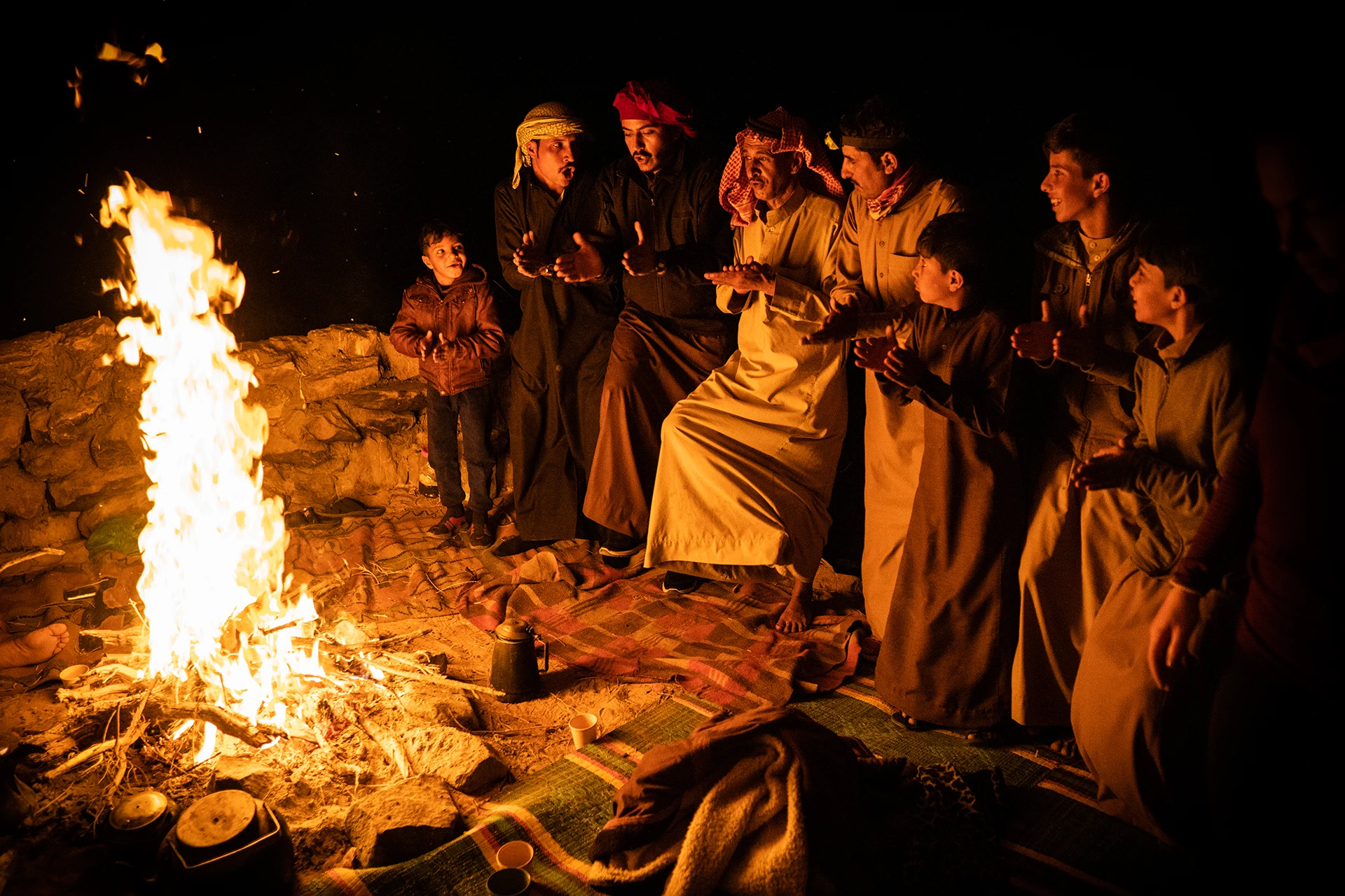 Groep mensen rond kampvuur in de avond
