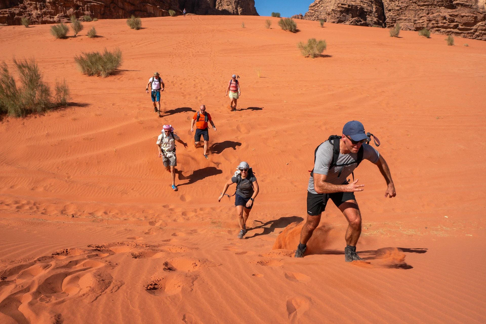 Hikers lopen door diep rood zand
