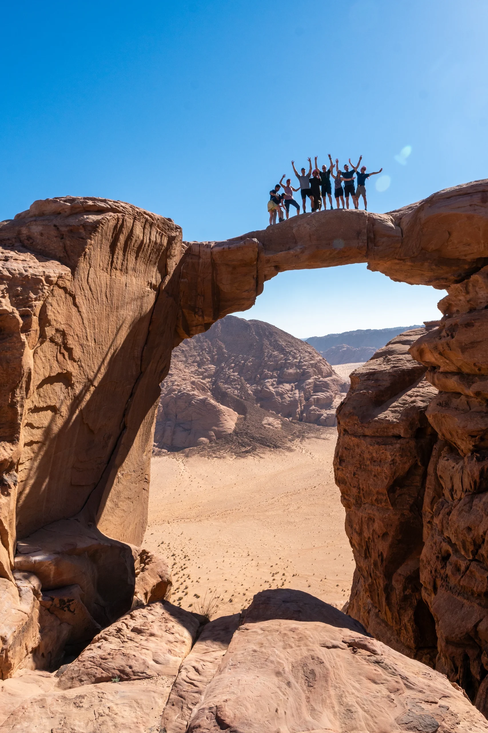 Groep mensen staat bovenop een natuurlijke rotsboog