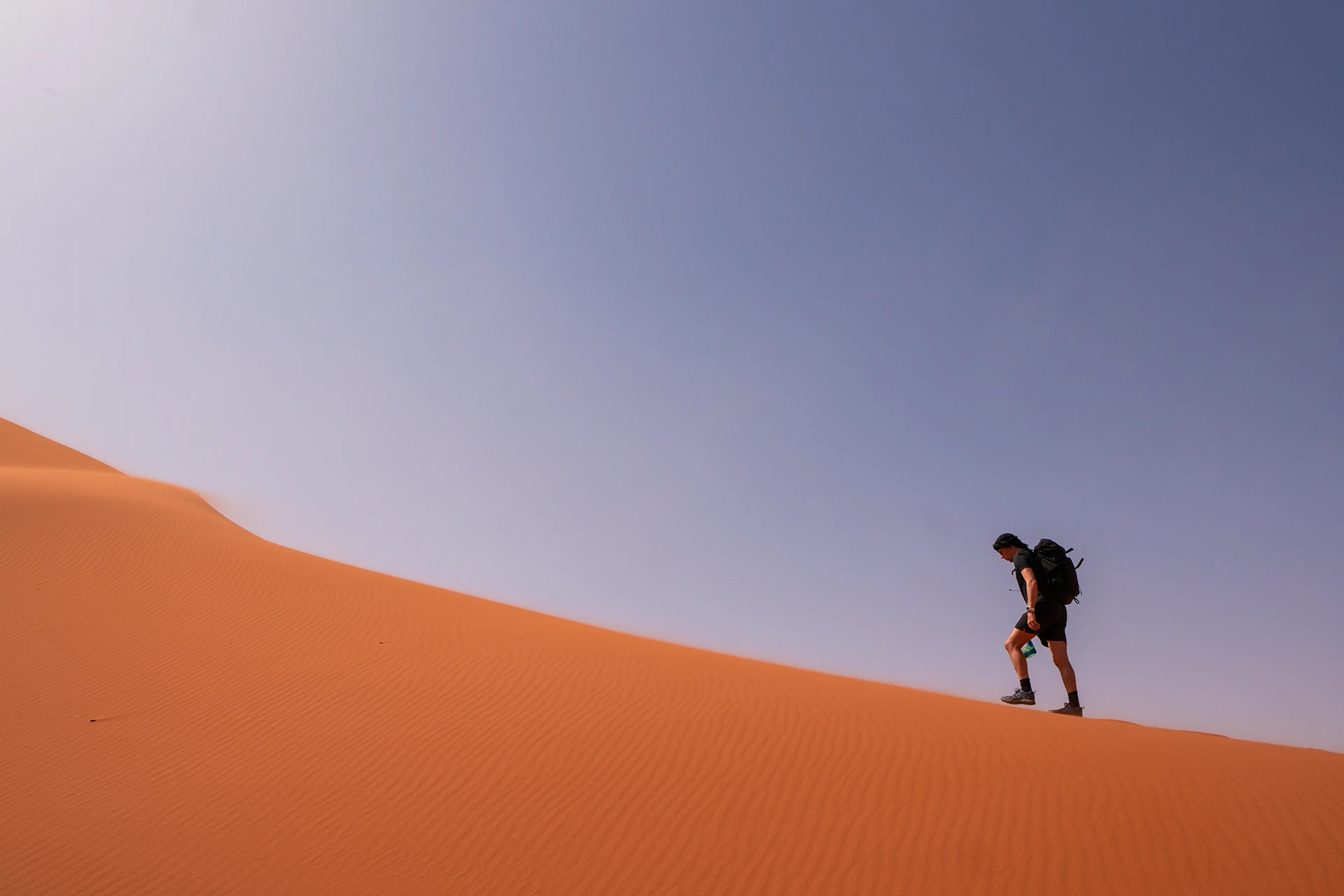 Wandelaar klimt een steile zandduin op