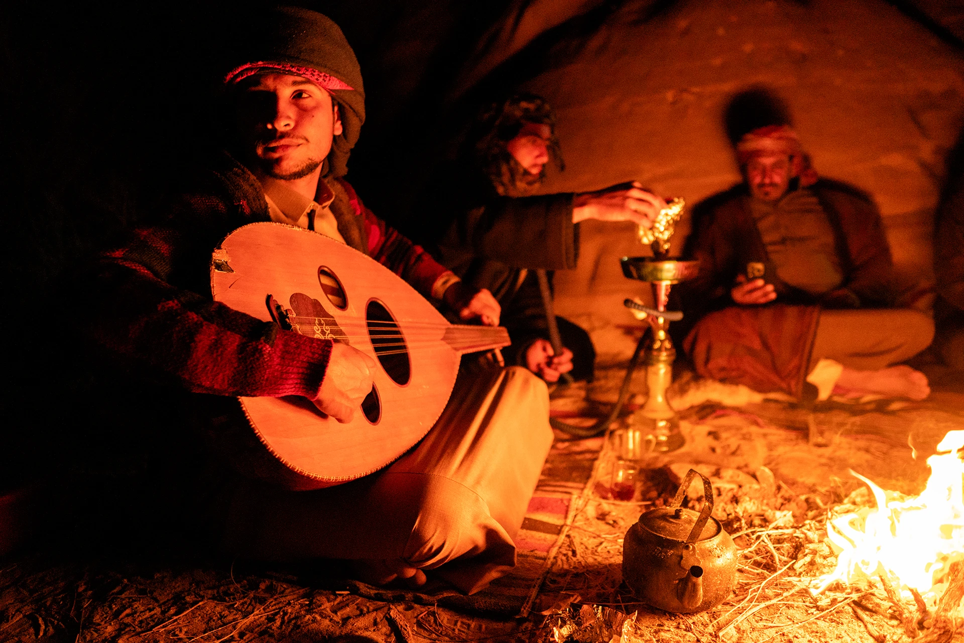 Mensen spelen muziek bij warm licht in een woestijntent