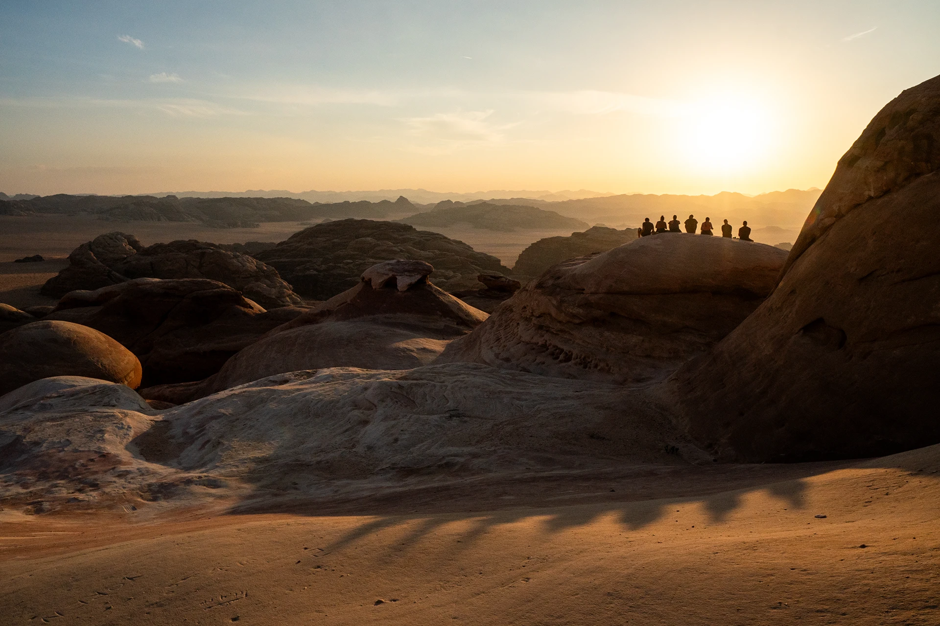 Zonsondergang over zandstenen heuvels in woestijngebied