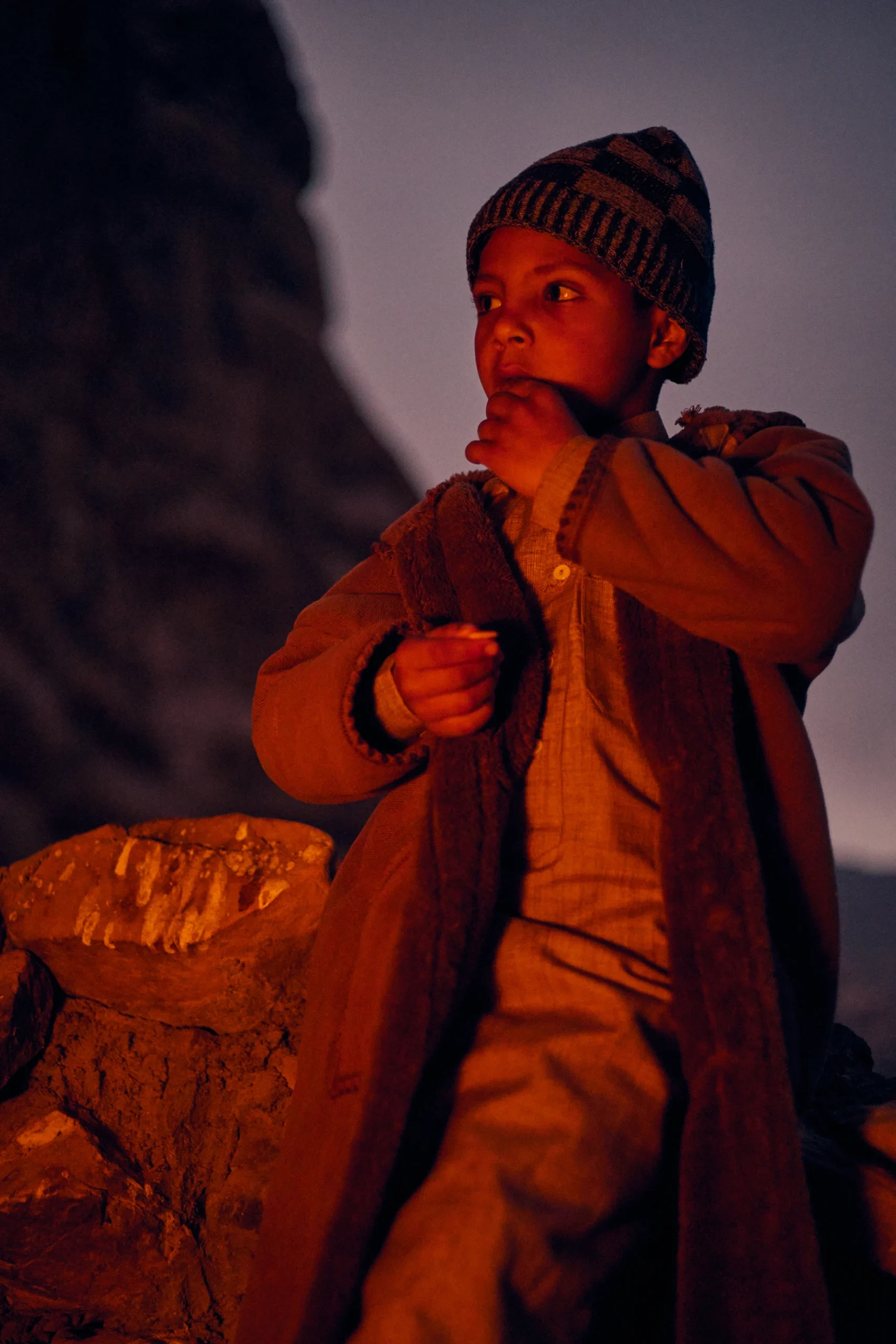 Kind staat in warm kampvuurlicht