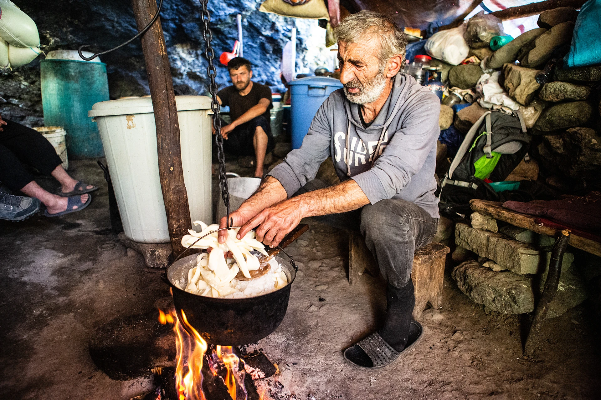 Man bakt brood in pan op open vuur