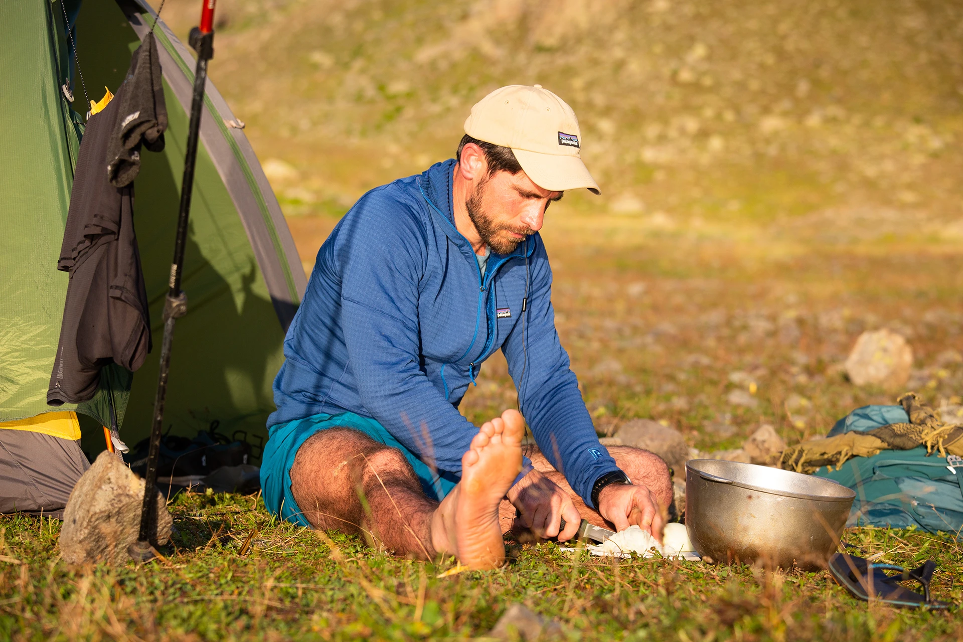 Man zit bij tent en kookt buiten