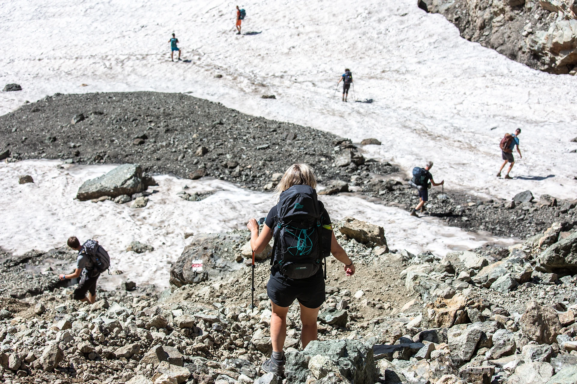 Wandelaar steekt gletsjersneeuw over met rugzak