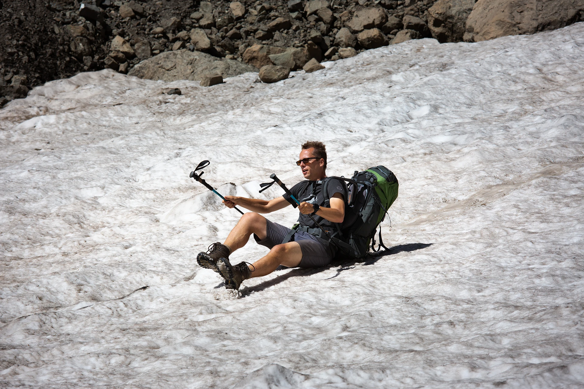Man glijdt met pickel over sneeuwveld