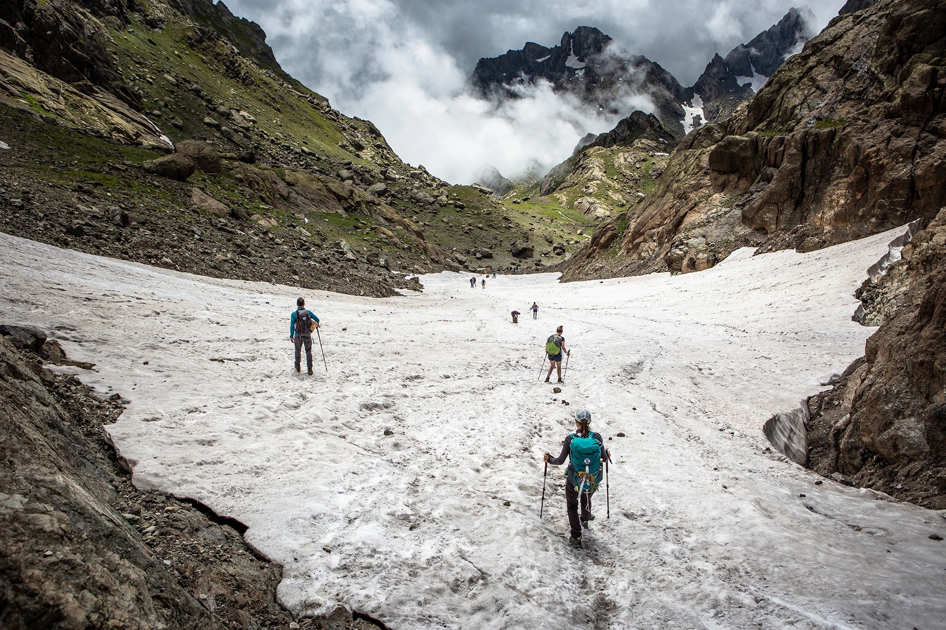 Wandelaar op gletsjer tussen steile rotsen