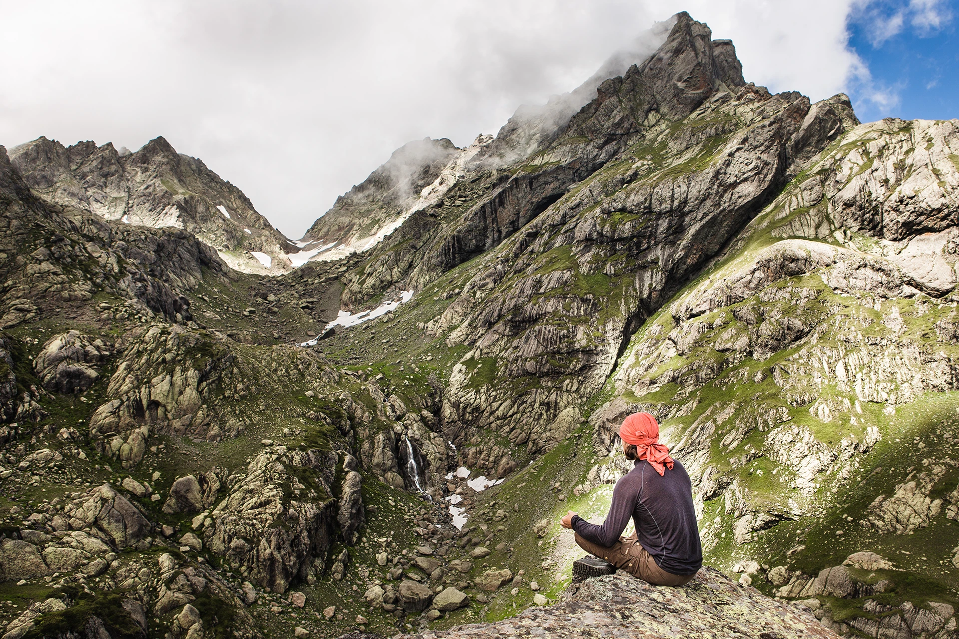 Twee hikers lopen door smal dal met hoge pieken